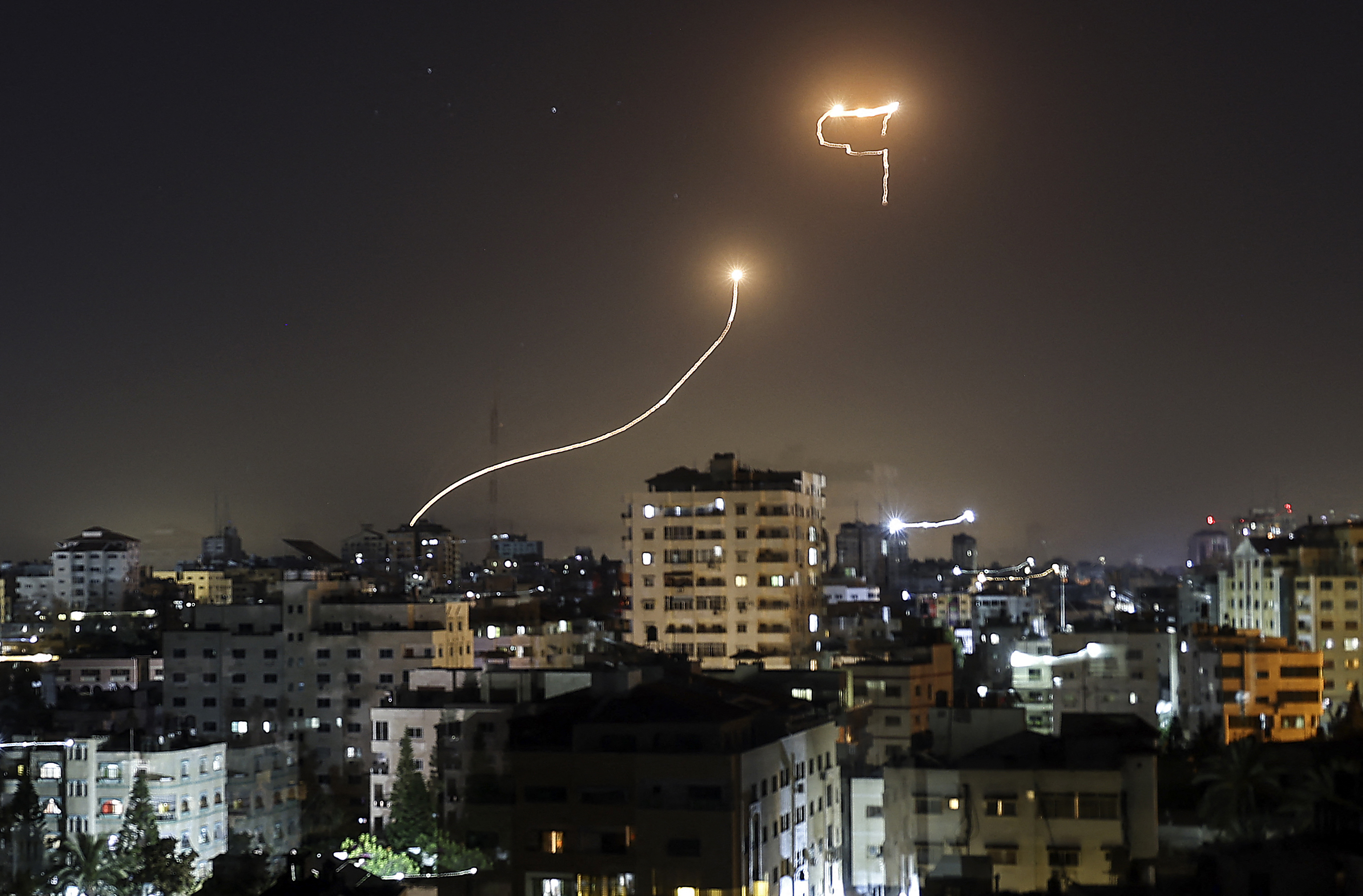 Kilatan cahaya ini adalah berkas dari misil anti rudal Israel (sering disebut Iron Dome) saat menghalau roket dari Gaza. Foto oleh: MAHMUD HAMS/AFP via Getty Images