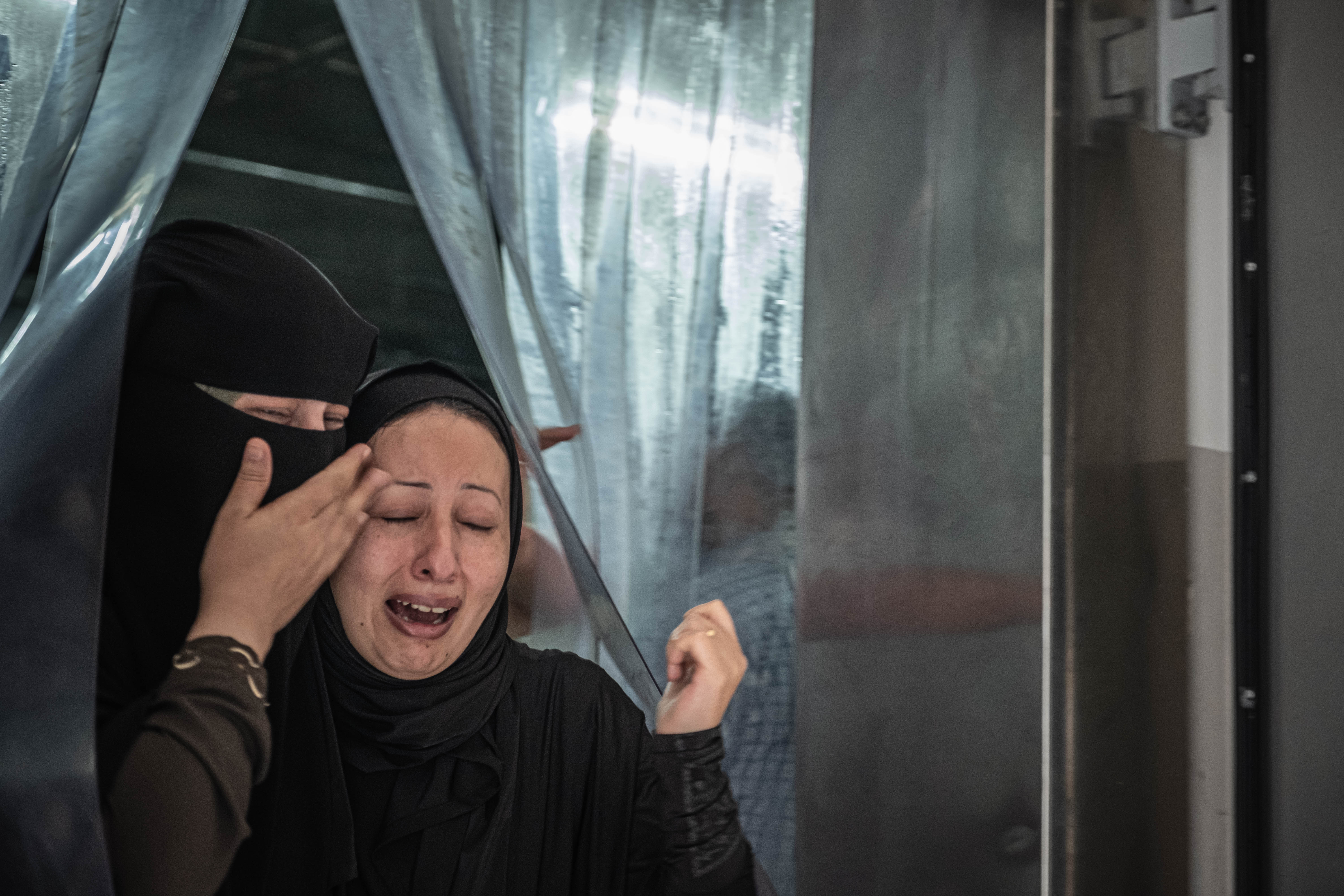Seorang perempuan menangisi saudaranya yang terbunuh akibat serangan udara Israel, di salah satu kamar jenazah RS Gaza. Foto oleh: Fatima Shbair/Getty Images