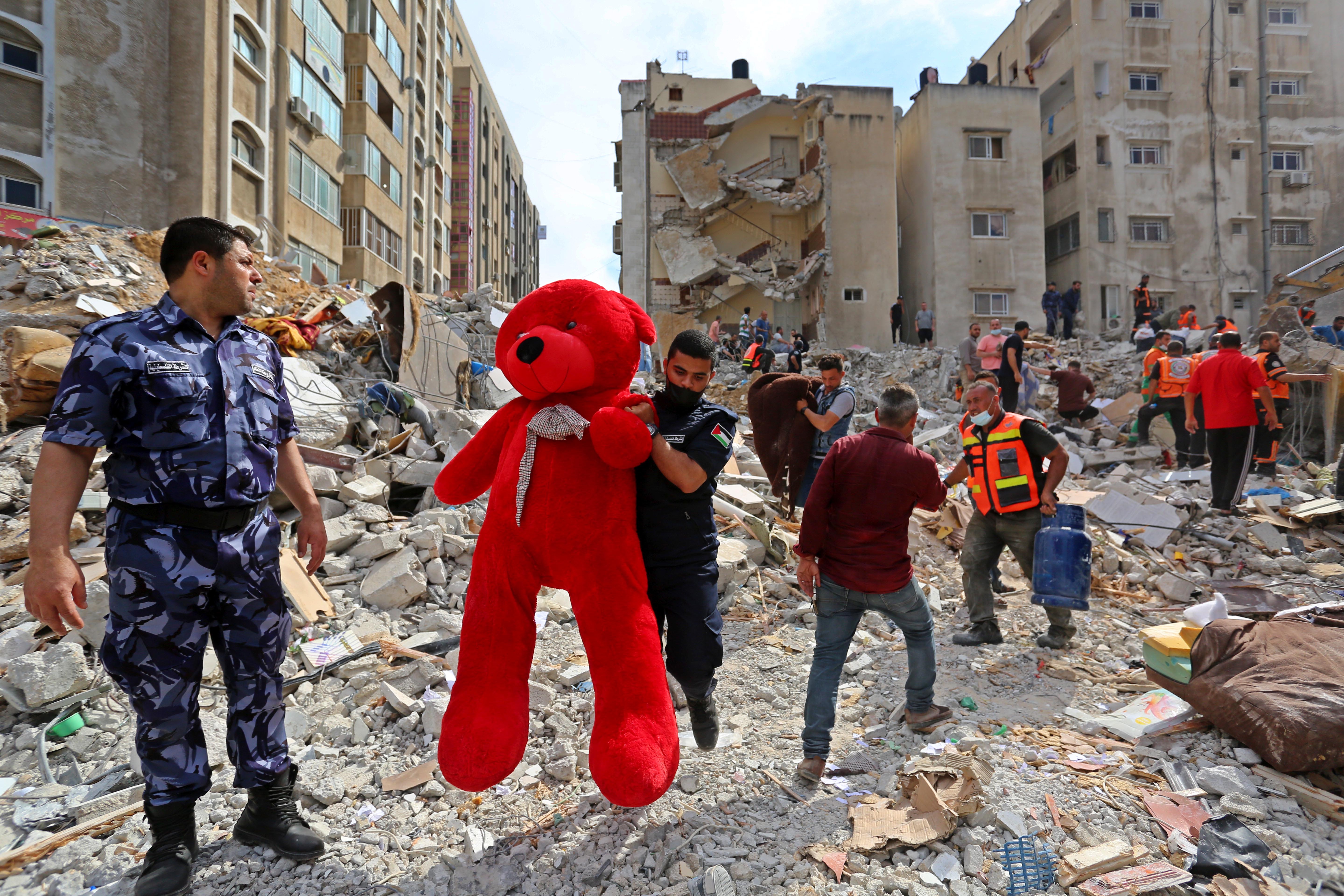 Sebuah boneka teddy bear diangkat oleh tim SAR yang berusaha mencari korban selamat dari serangan udara Israel yang menghantam salah satu apartemen di Gaza. Foto oleh: Ashraf Amra/Anadolu Agency via Getty Images