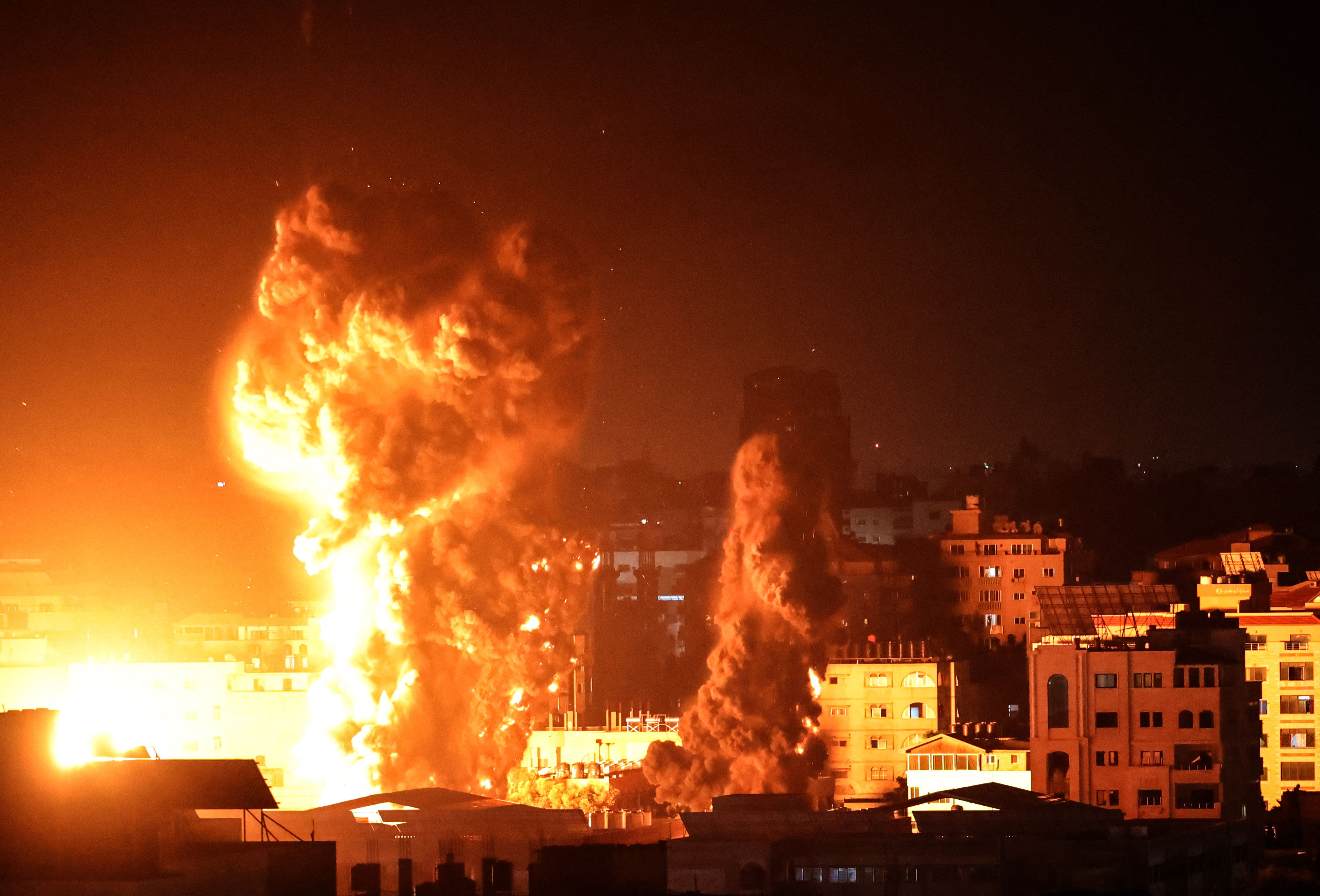 Foto ini diambil menjelang pergantian hari menuju 17 Mei 2021, saat sebuah permukiman di Gaza terkena serangan rudal jet tempur Israel. Foto oleh ANAS BABA/AFP via Getty Images