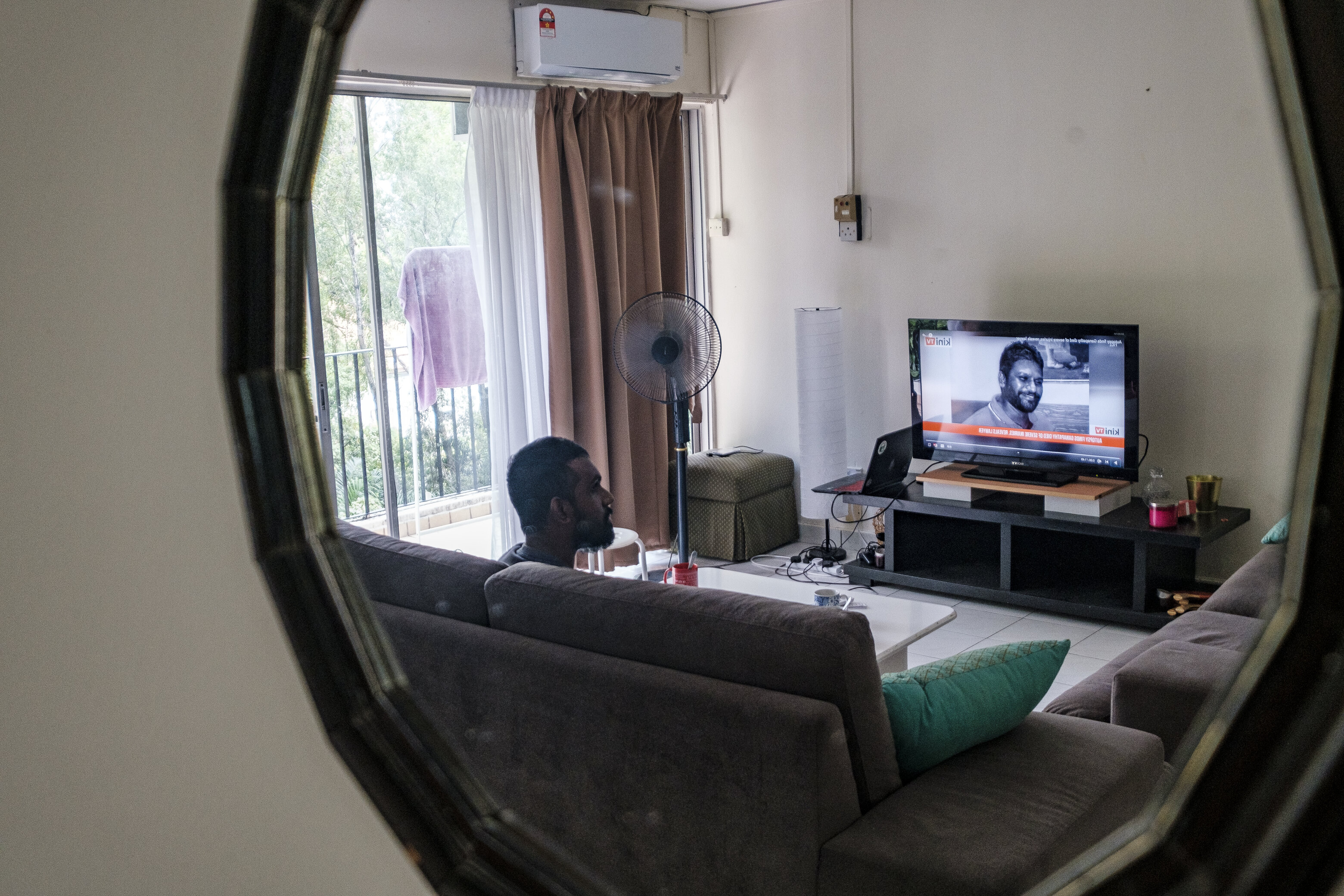 Pingalayen Kumar in his living room, watching media coverage of ongoing police brutality in the country​. Photo: Farhan Iqbal 