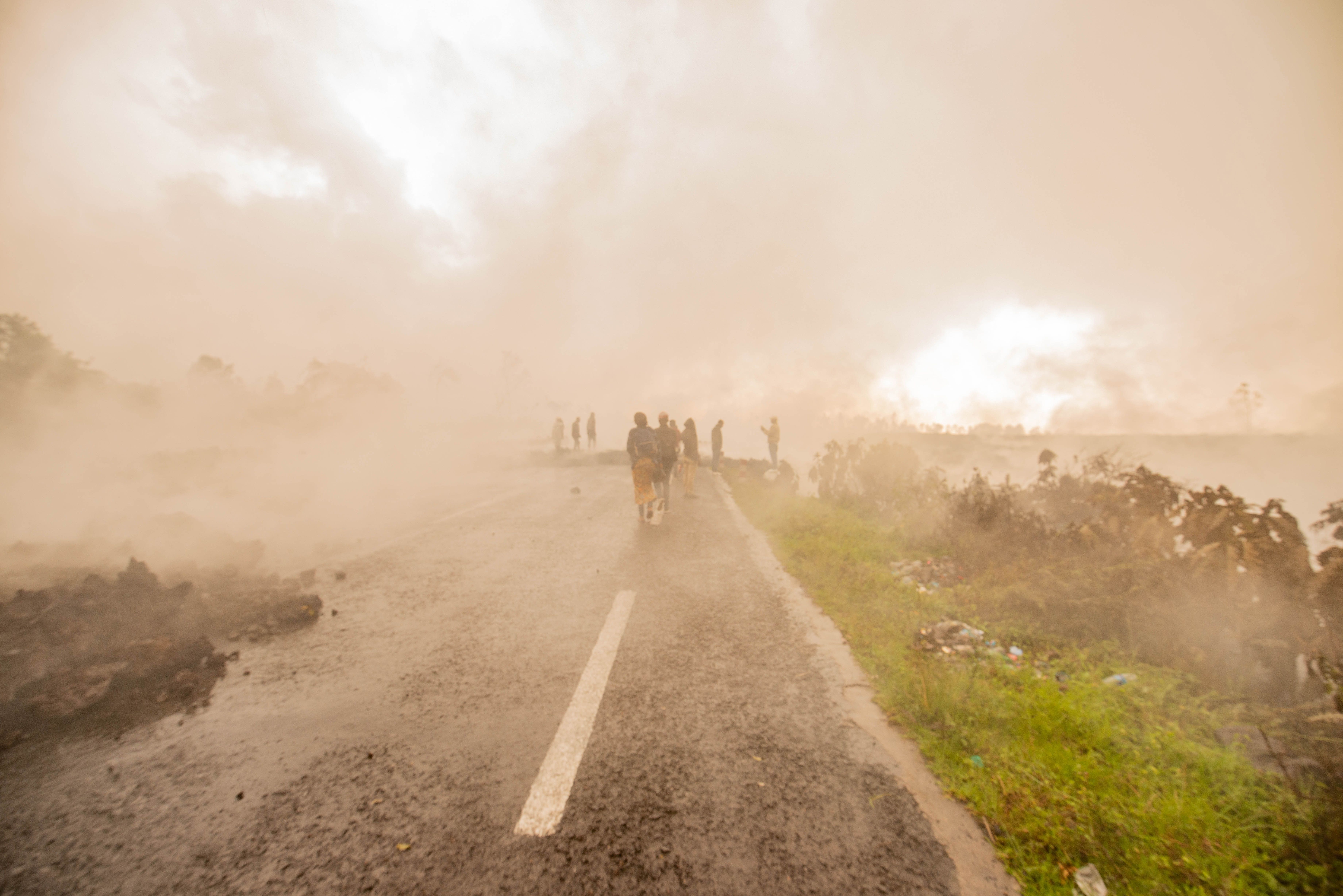 Warga berjalan melewati kepulan asap di Kota Goma. Foto: Moses Sawasawa/AFP via Getty Images