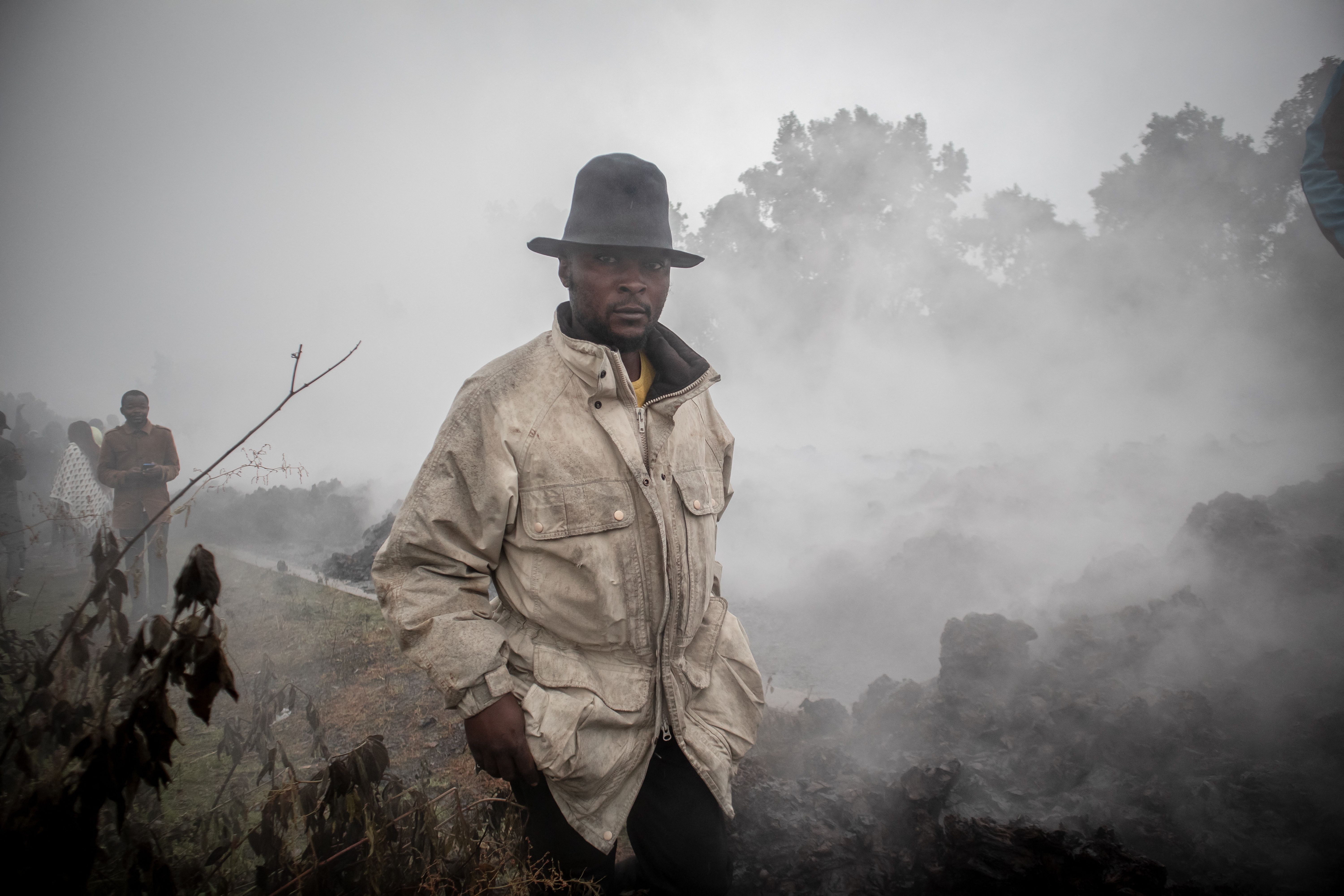 Warga pulang ke rumah saat asap masih mengepul. Foto: Guerchom Ndebo/AFP via Getty Images.