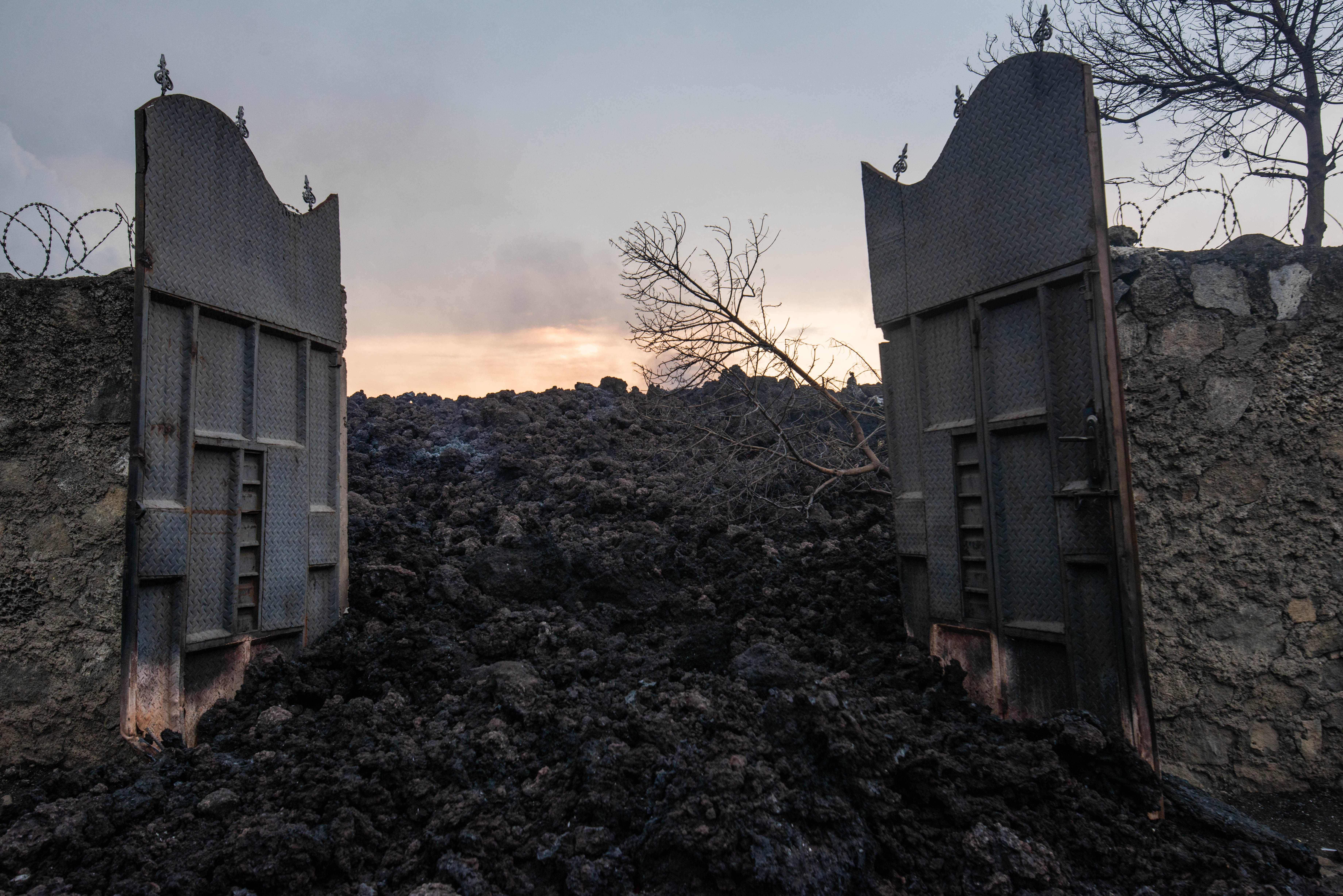 Muntahan lahar membanjiri pintu masuk rumah di pinggiran kota Goma. Foto: Moses Sawasawa/AFP via Getty Images