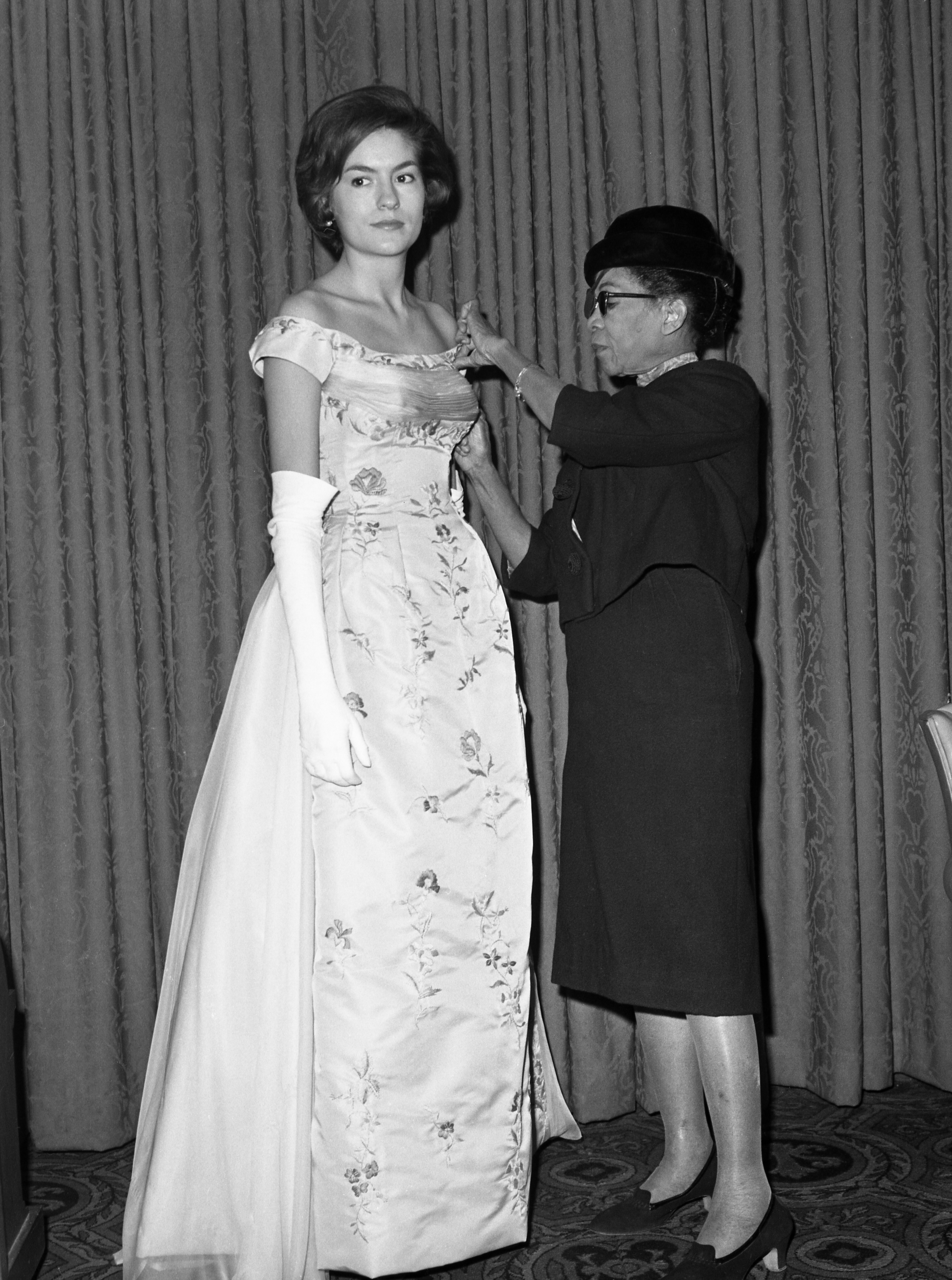 Fashion designer Ann Lowe adjusting the bodice of a client's dress