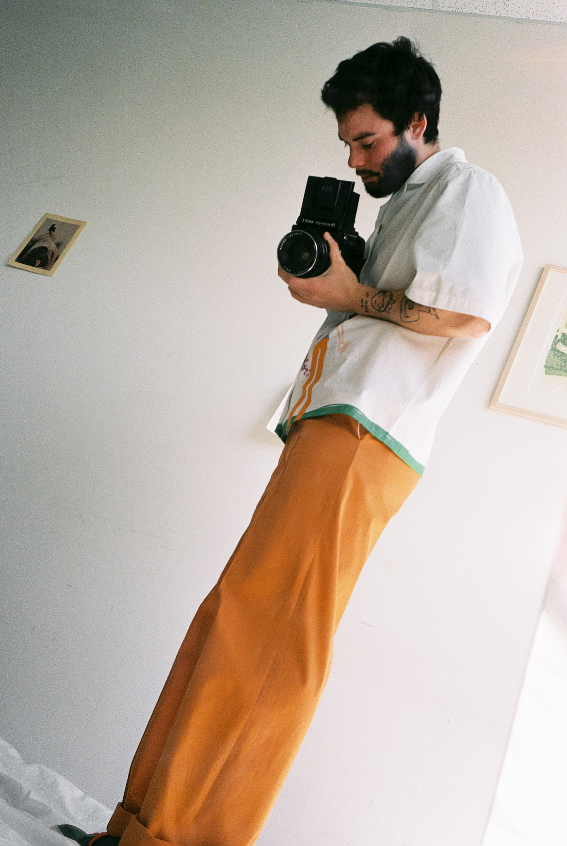 foto di francesco cicconetti mehths con in mano macchina fotografica, con indosso pantaloni arancio e con indosso a-o bowling shirt di Federico Cina, foto Sara lorusso