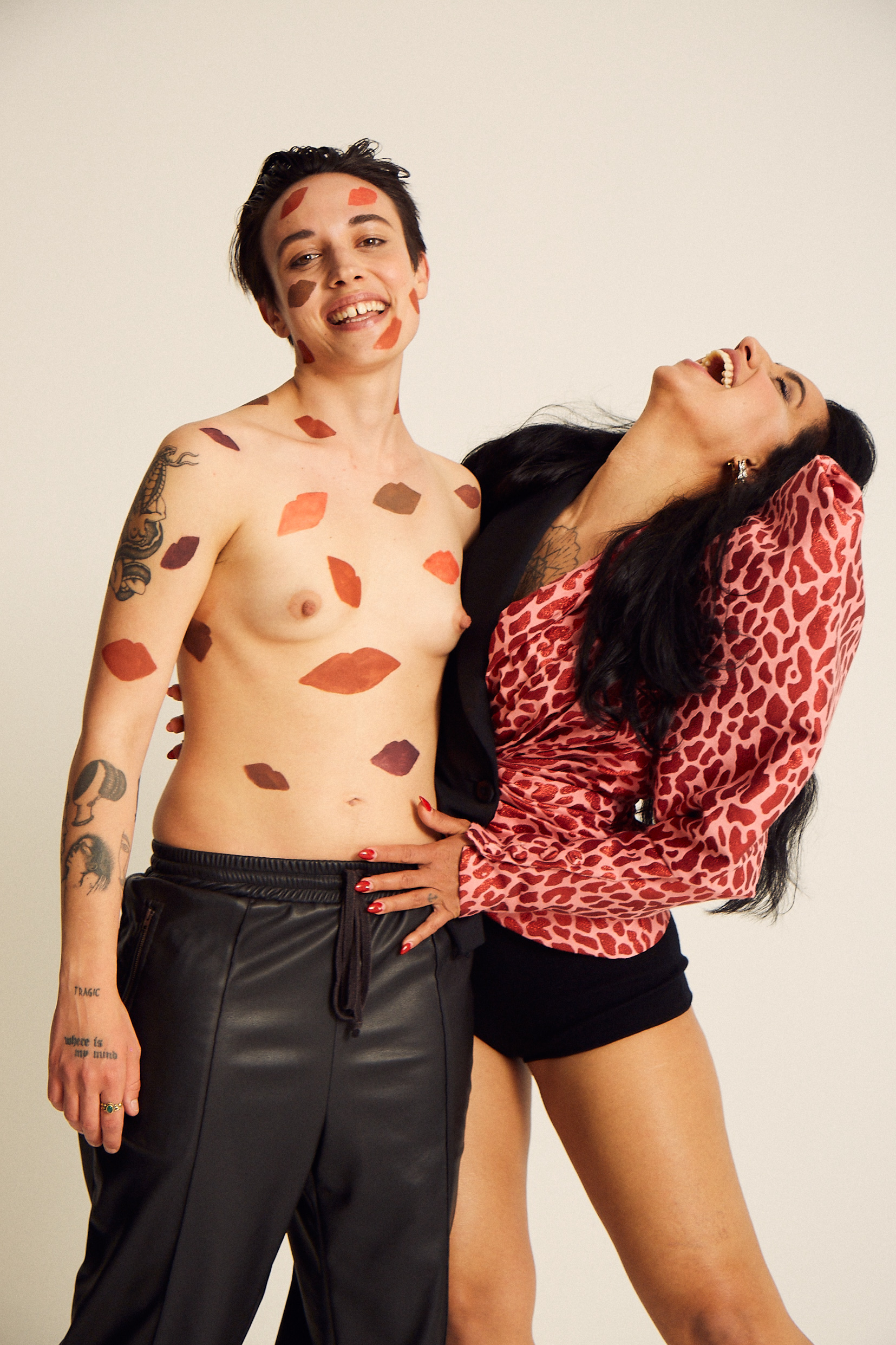 coppia lesbica che ride una persona nonbinary tatuata e una ragazza che ride