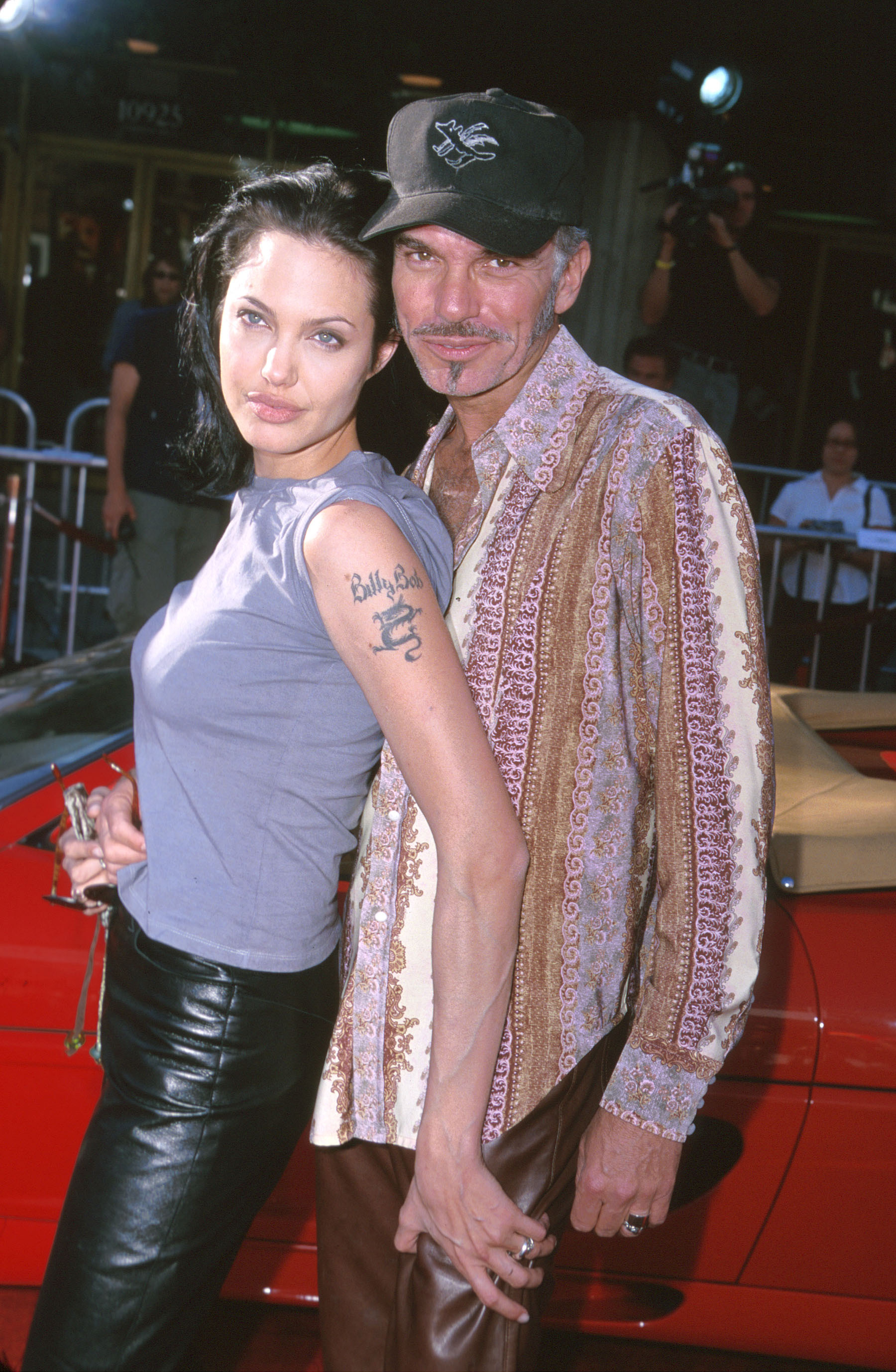 angelina jolie grabbing billy bob thorntons leg and posing at a movie premiere