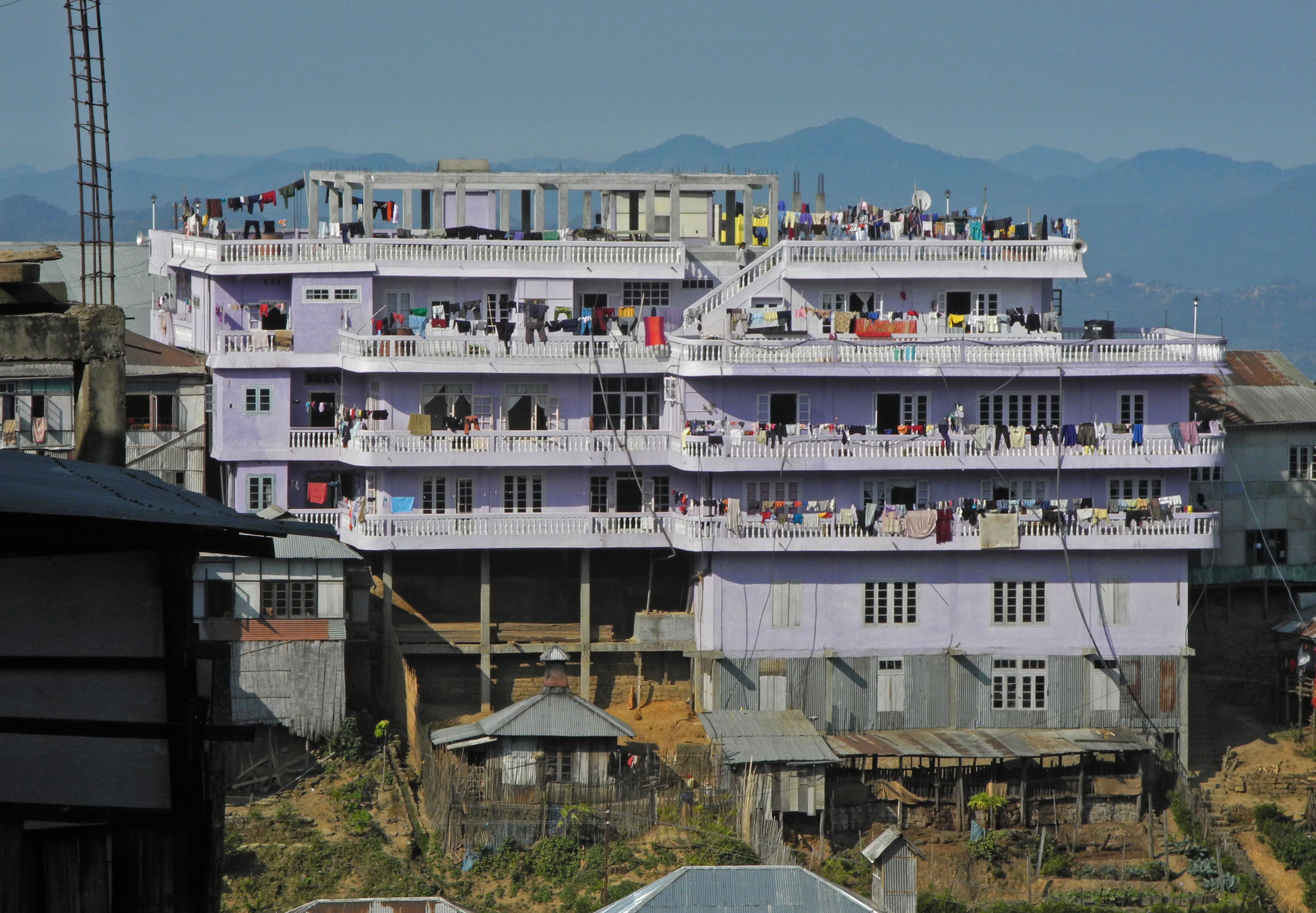 Rumah empat lantai berwarna ungu muda milik keluarga besar Ziona. Dikenal dengan nama “Chhuan Thar Run”, rumah ini menjadi destinasi wisata favorit di Mizoram. Foto: Richard Grange/Getty Images