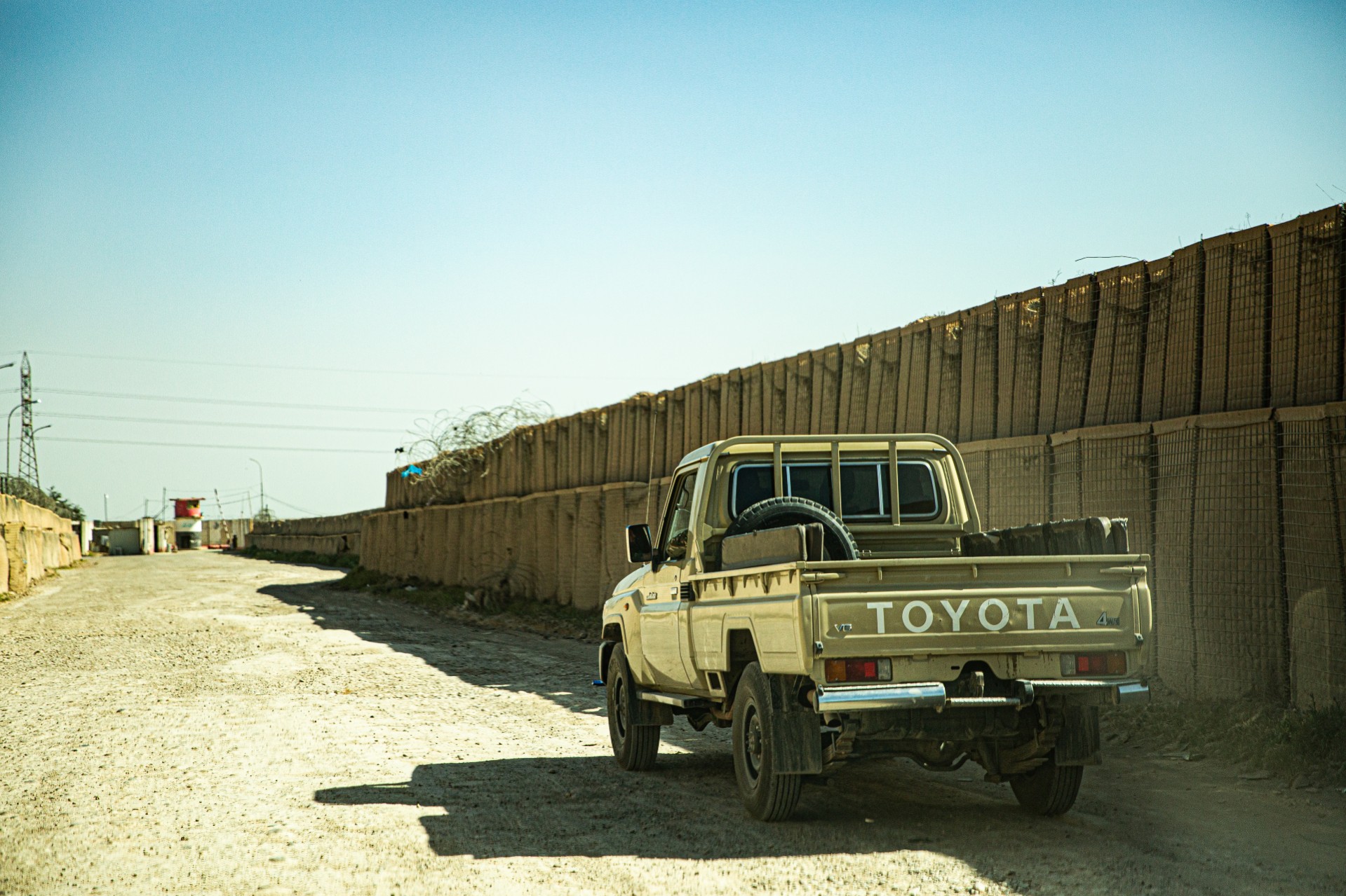 Mobil melewati jalanan bertembok di Irak.