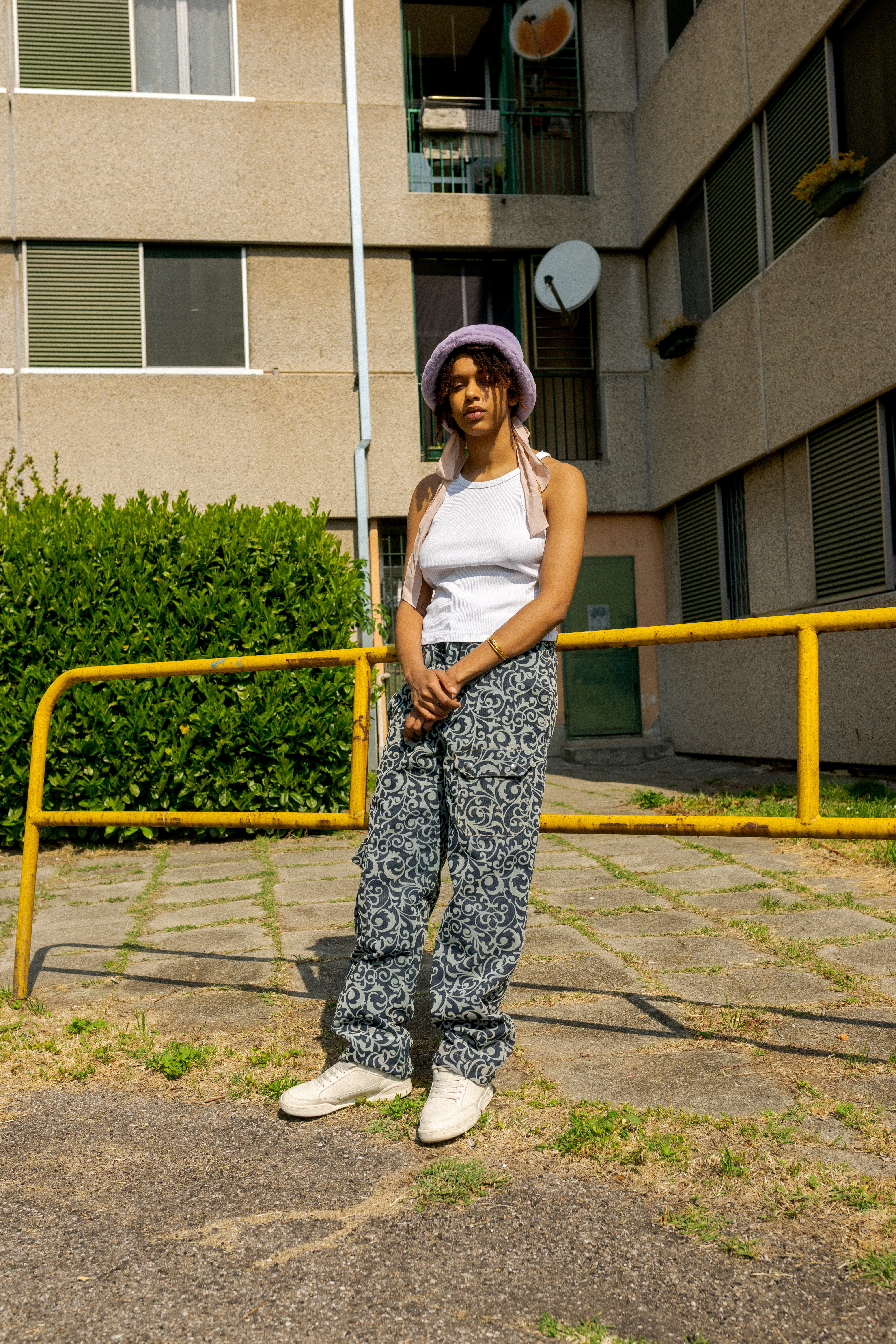 YOUTH: le seconde generazioni di Milano si raccontano - ragazza davanti a edifici in cemento con cappellino rosa