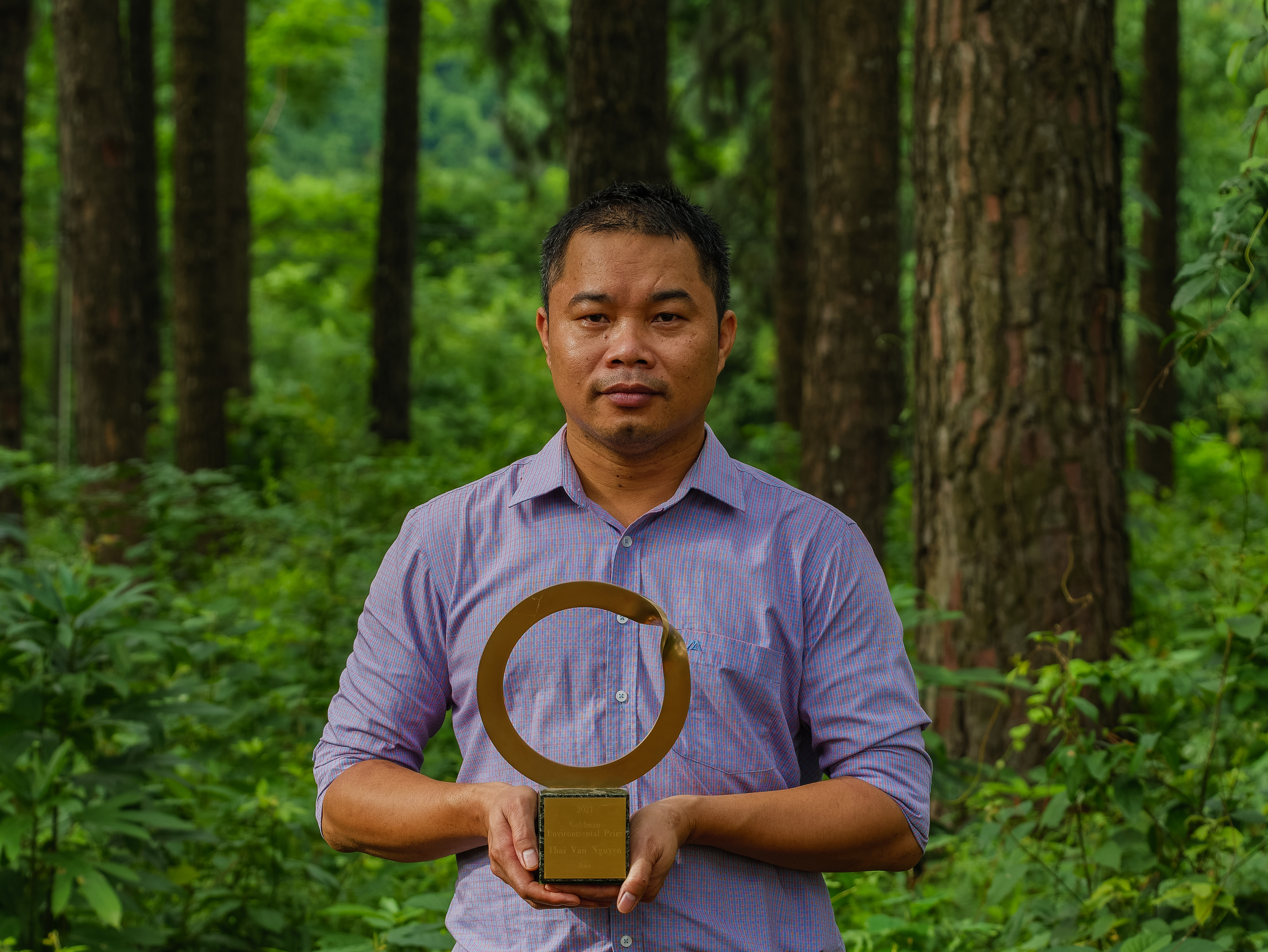 Thai Van Nguyen memamerkan piala Penghargaan Lingkungan Goldman