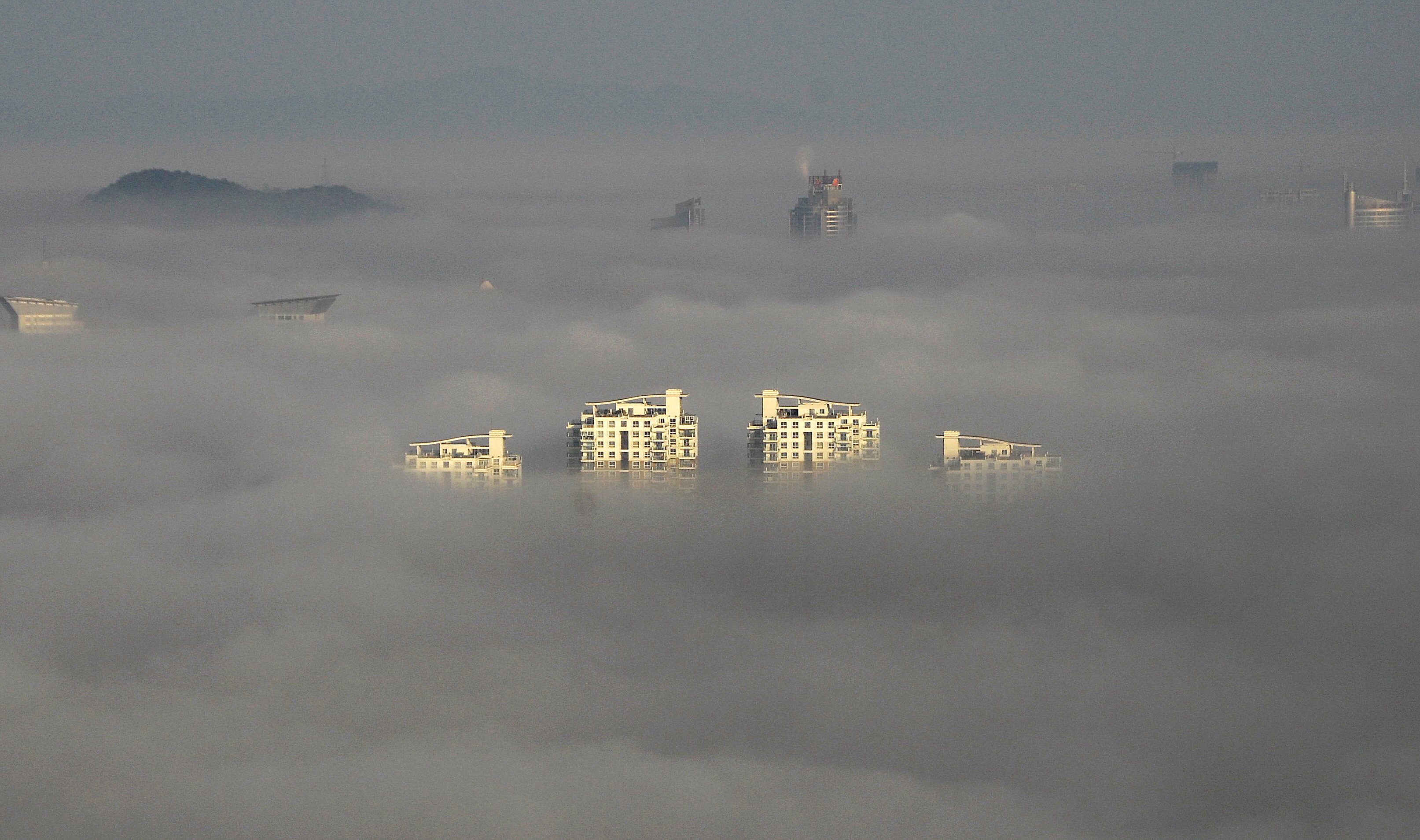 Fog obscures the tops of buildings in Wenling, China's Zhejiang province. Photo: AFP via Getty Images