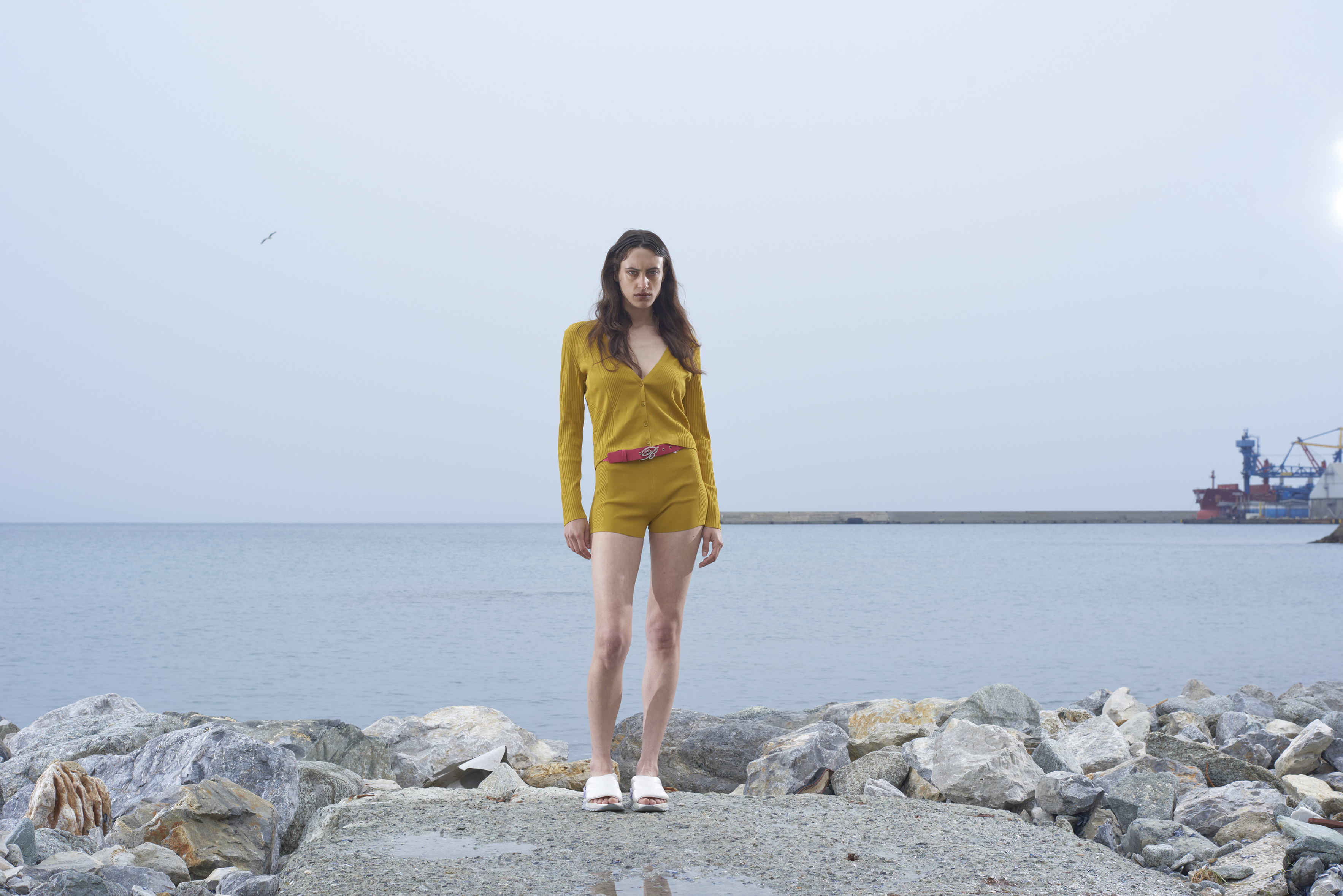ragazza su una spiaggia di rocce in paesaggio post-sovietico