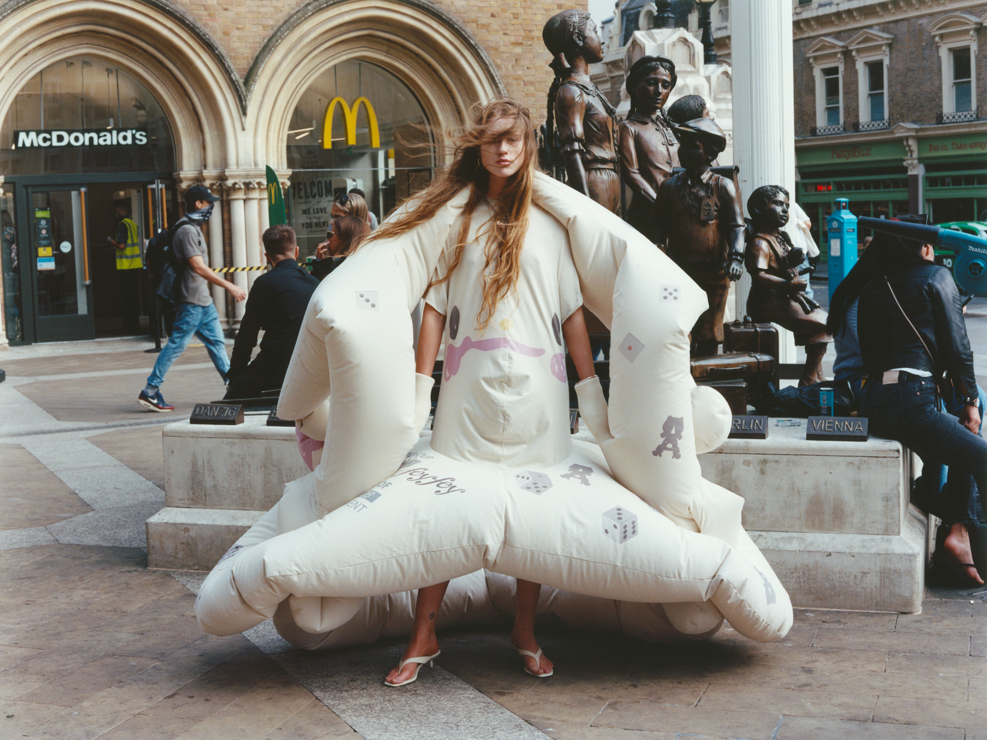 a woman walking through london wearing an inflatable dress by RCA MA Fashion graduate Fey Fey