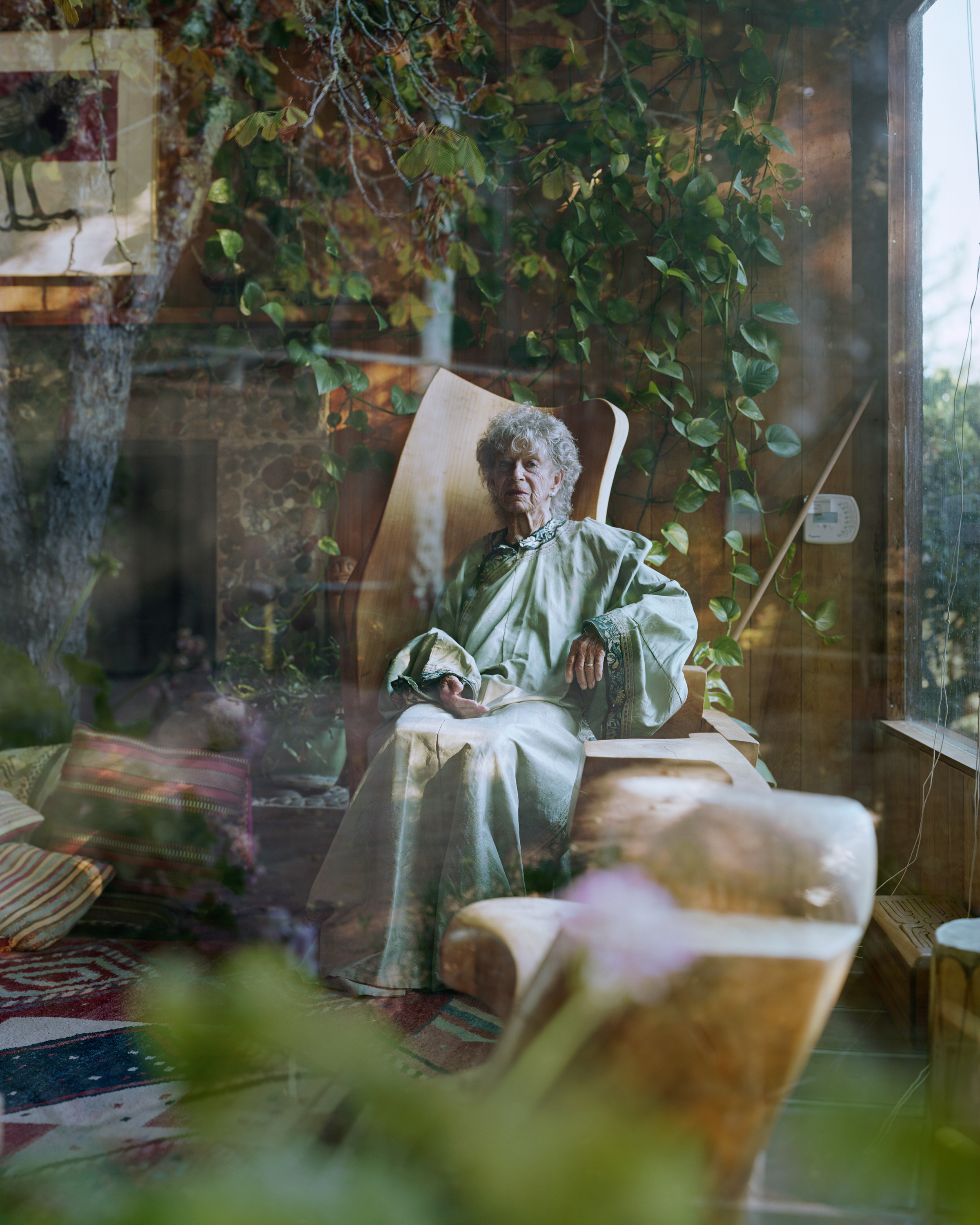 donna anziana seduta su poltrana con attorno delle piante, foto di Alec Soth