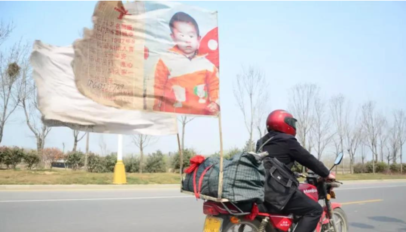 Guo mengendarai motor dengan spanduk besar berkibar di belakangnya Foto: CCTV