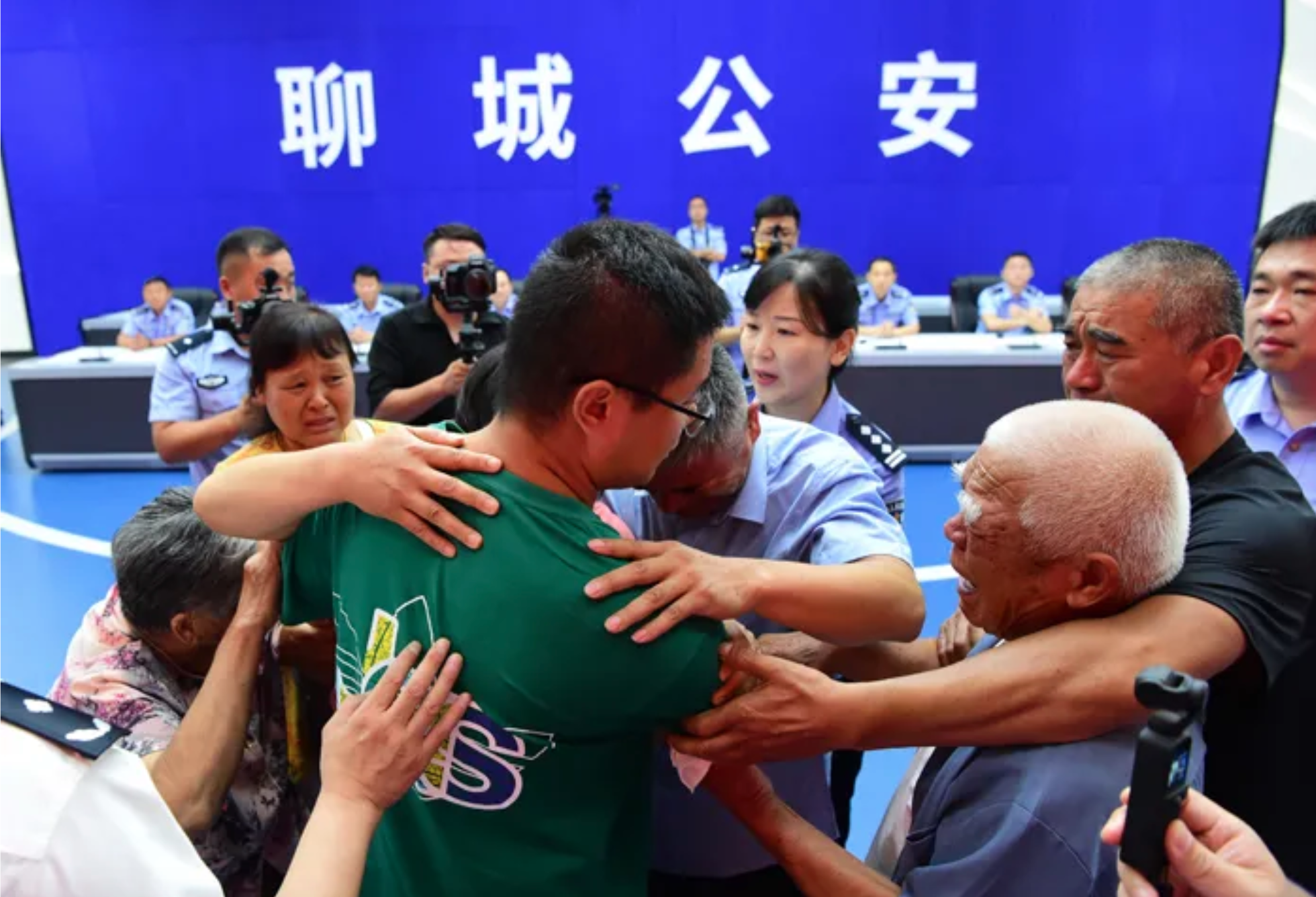 Guo Gangtang (lelaki tua yang memakai kemeja biru muda) berpelukan dengan putranya Guo Xinzhen (kaus hijau). Foto: Biro Keamanan Publik Liaocheng