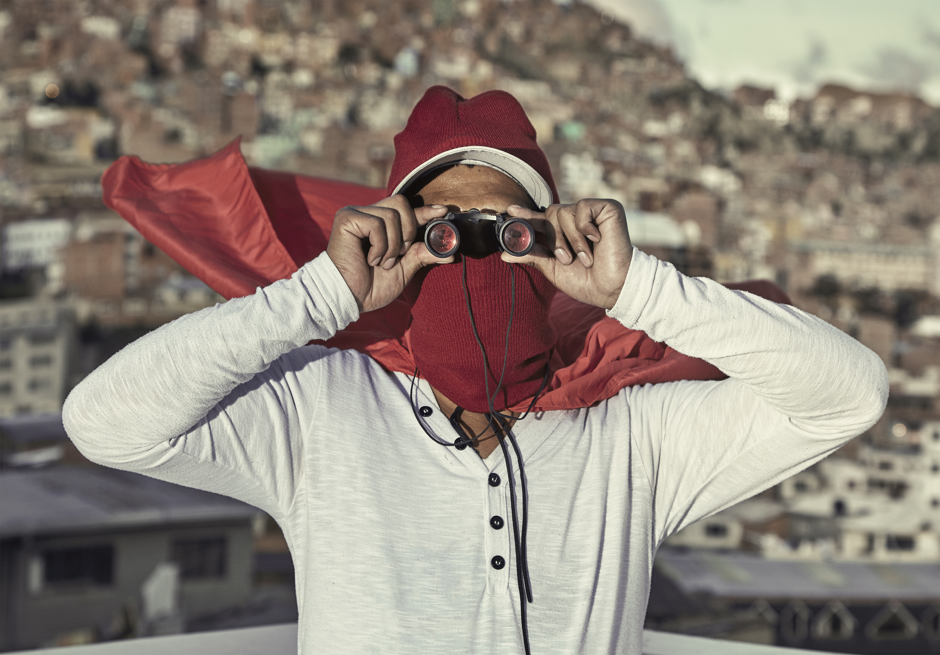 ragazzo con binocolo davanti a città su una montagna Federico Estol