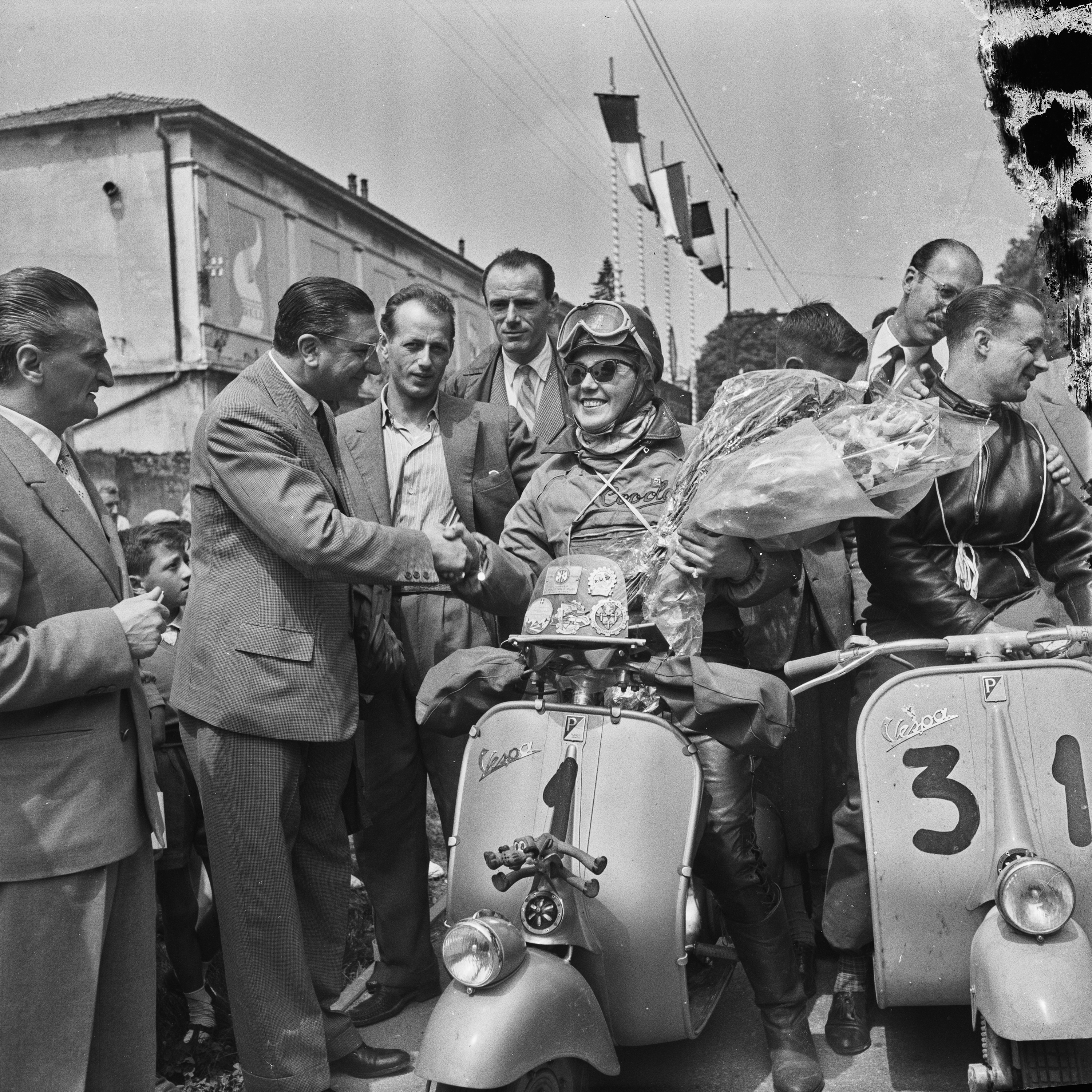 foto vecchia con persone attorno a un motociclista in vespa Archivio Publifoto Intesa Sanpaolo
