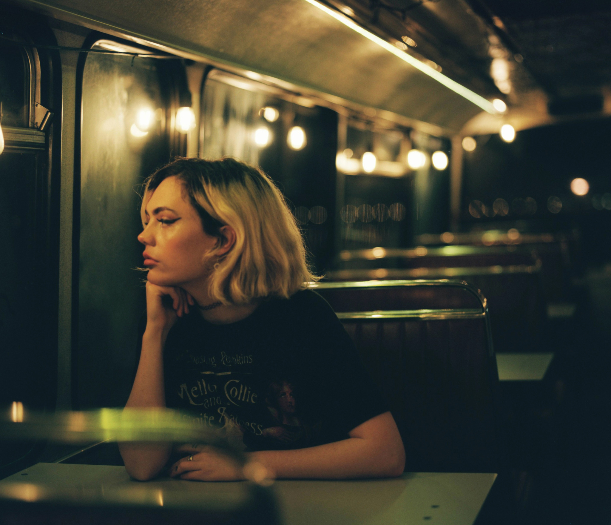 ragazza che guarda fuori dalla finestra di un diner