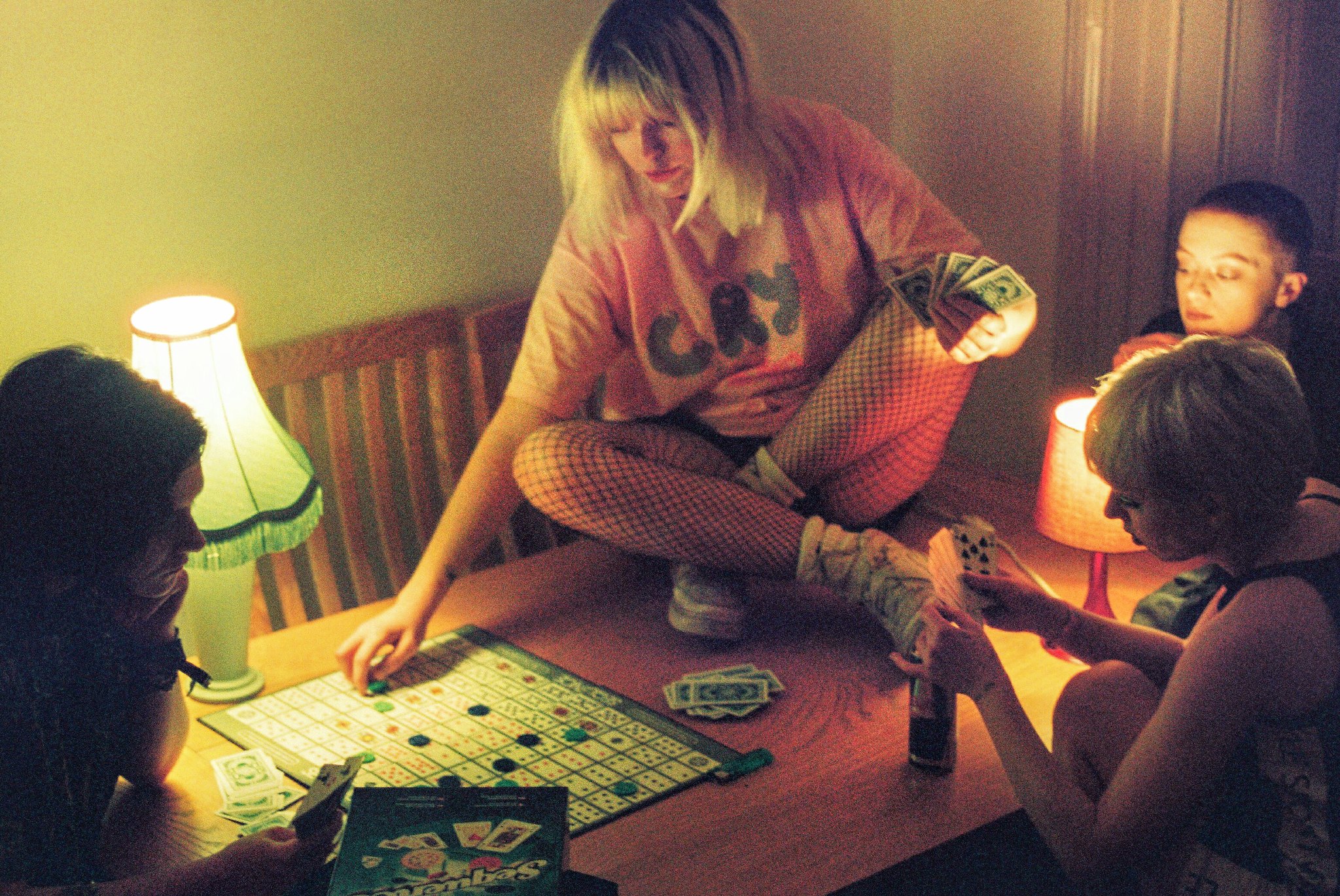 ragazza su un tavolo che gioca con le altre in mezzo a giochi da tavolo
