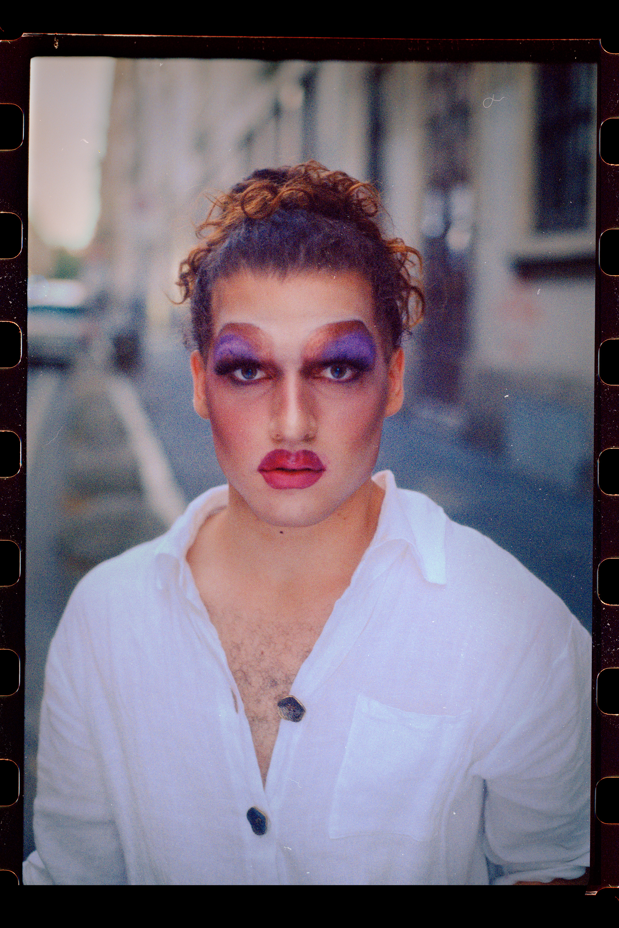 prsona con trucco da drag e camicia bianca