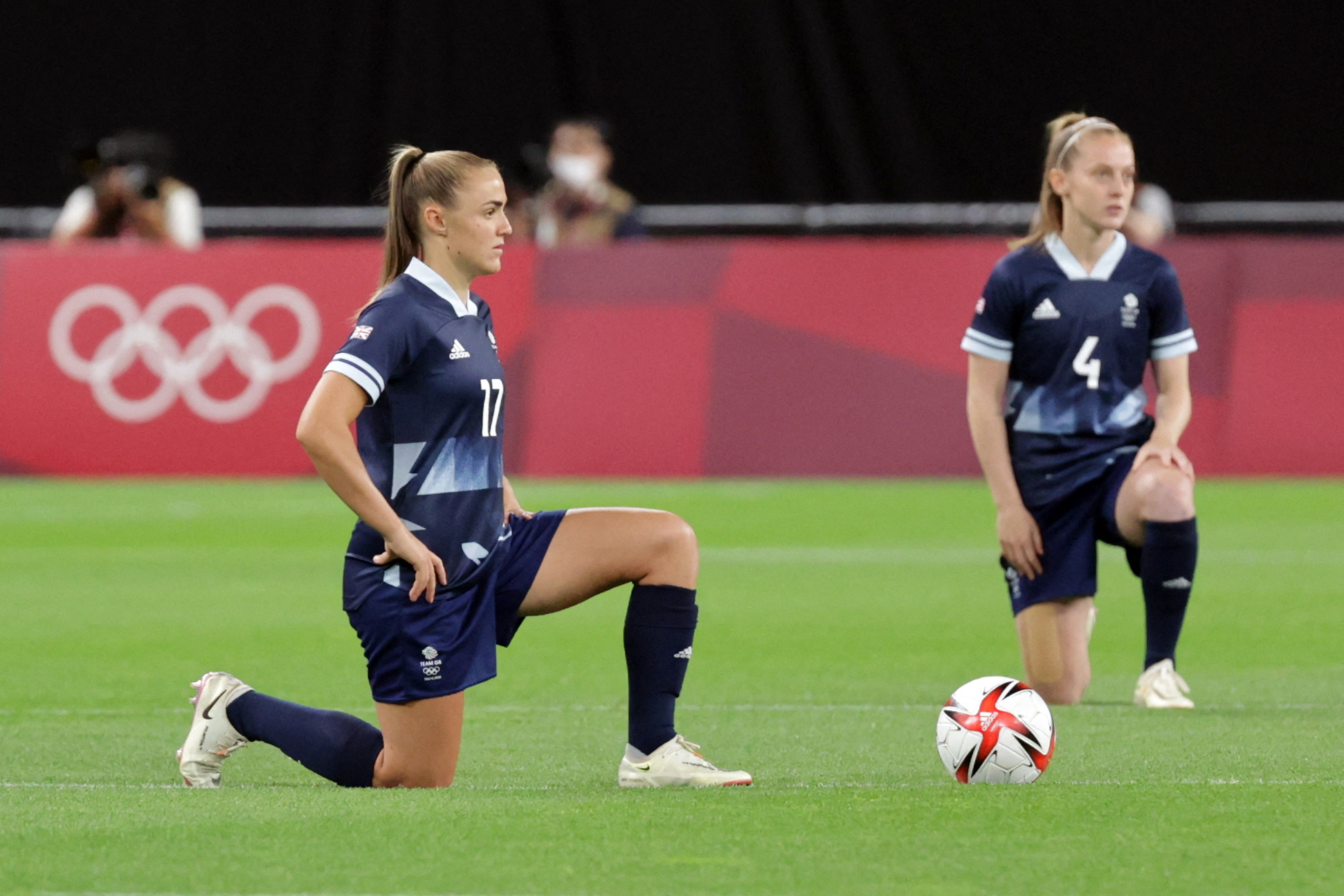 British soccer players Georgia Stanway (left) and Keira Walsh take a knee before a first round Olympic soccer match at the Sapporo Dome in Sapporo on Wednesday. Photo: ASANO IKKO / AFP