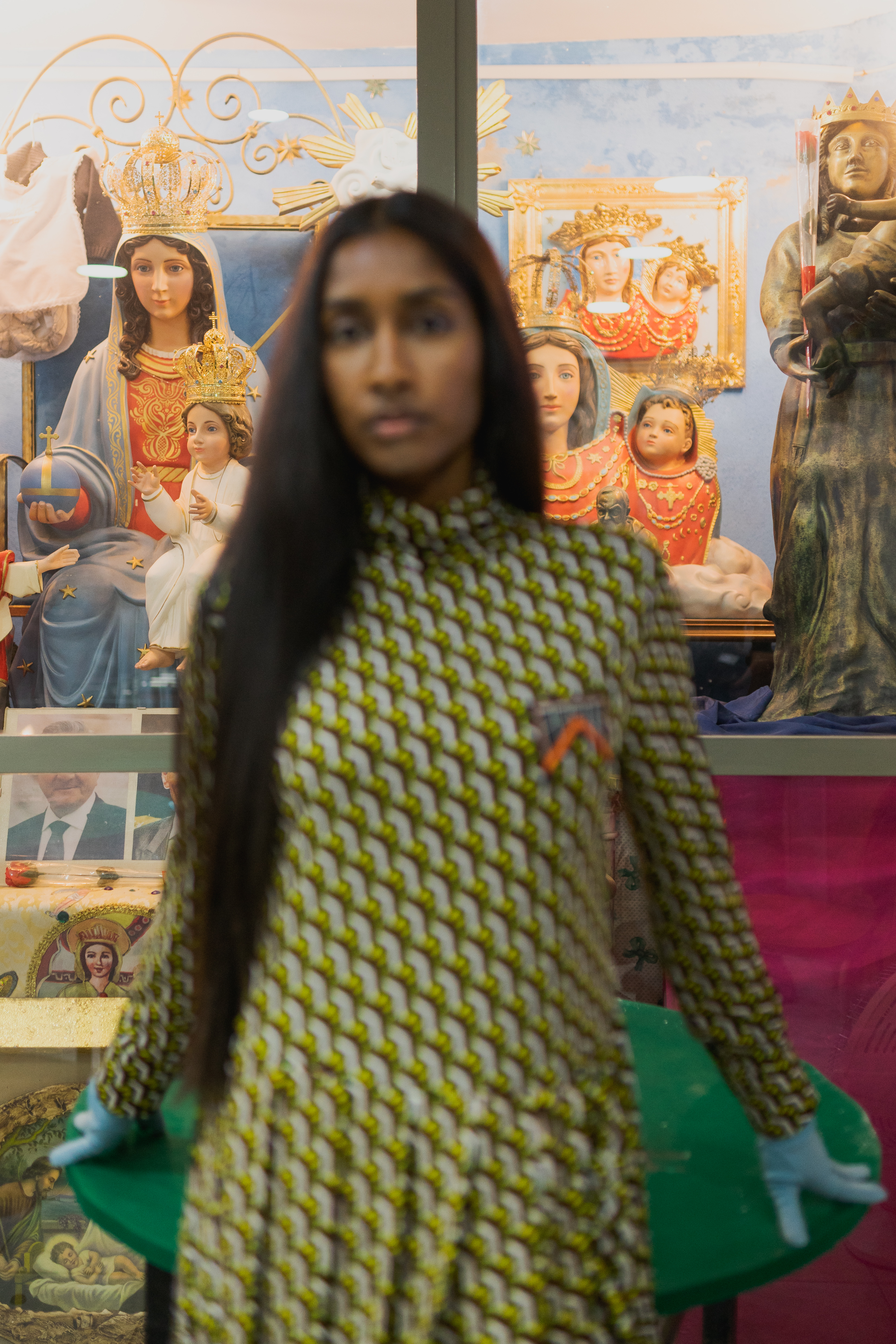 ragazza con vestito con dietro statuette votive