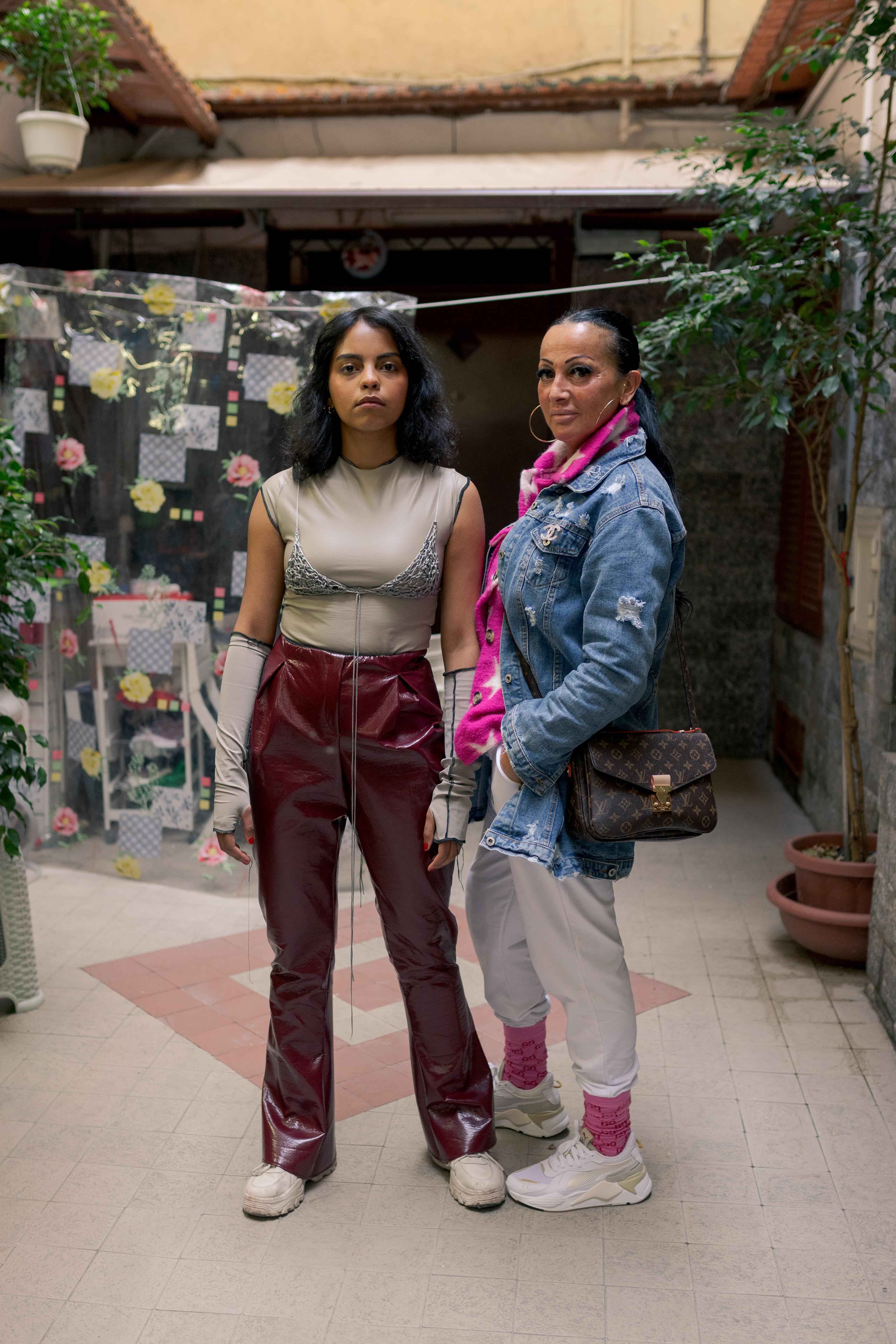 ragazza con pantaloni in vinile rossi affianco altra persona