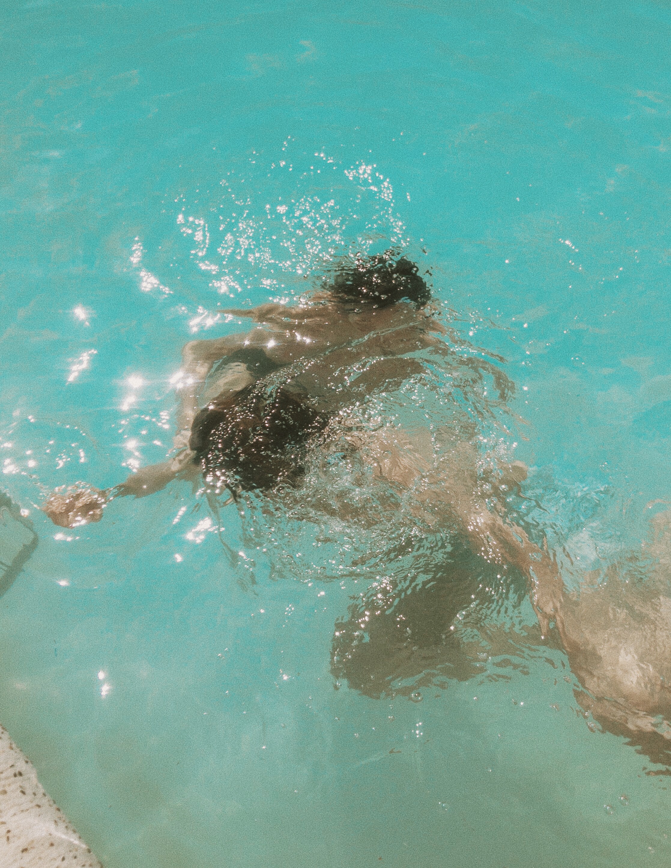 People under water taking a selfie in a pool.