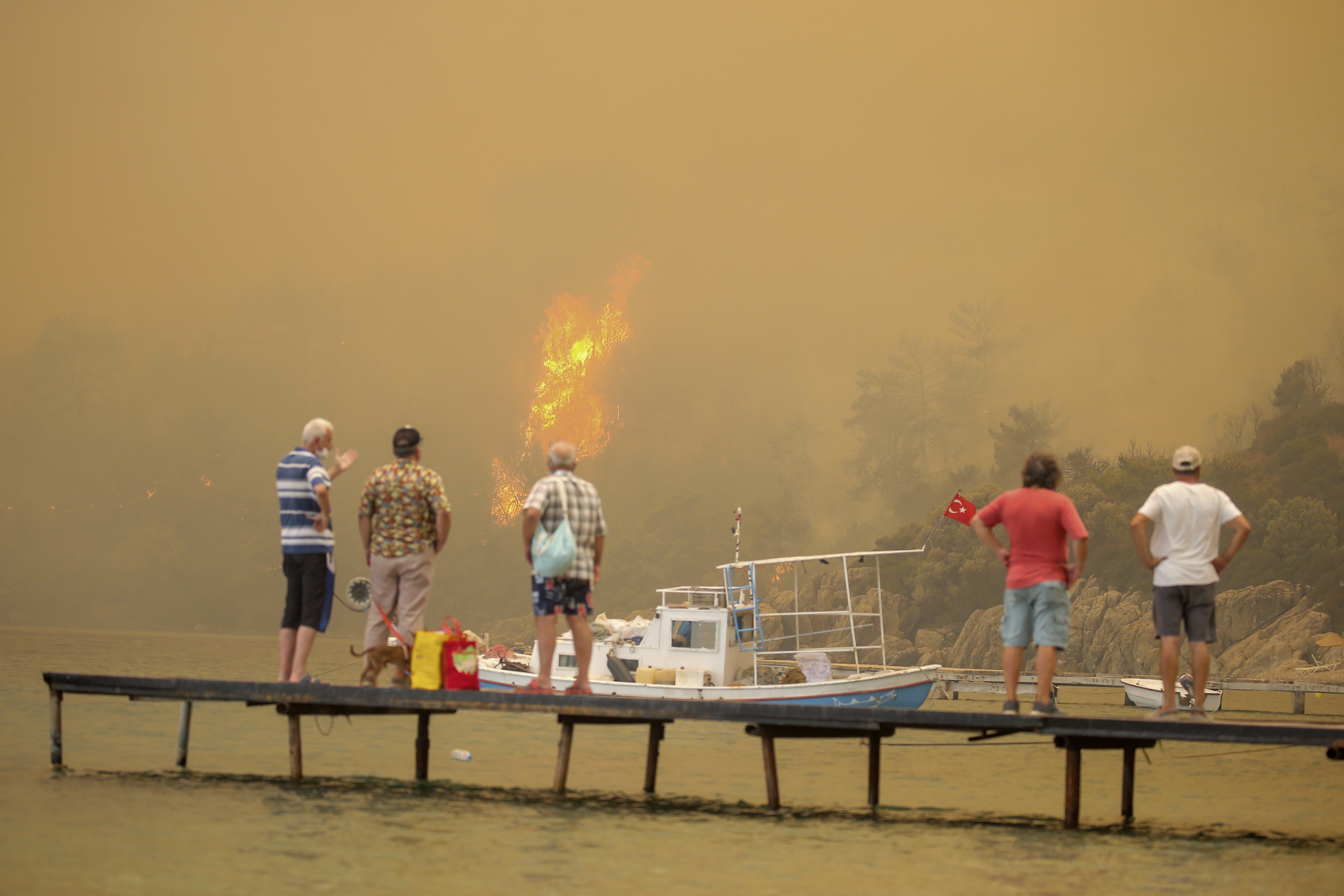 Tourists wait to be evacuated as wildfires rolled down the hill in Bodrum on the 1st of August. Photo: AP Photo/Emre Tazegul