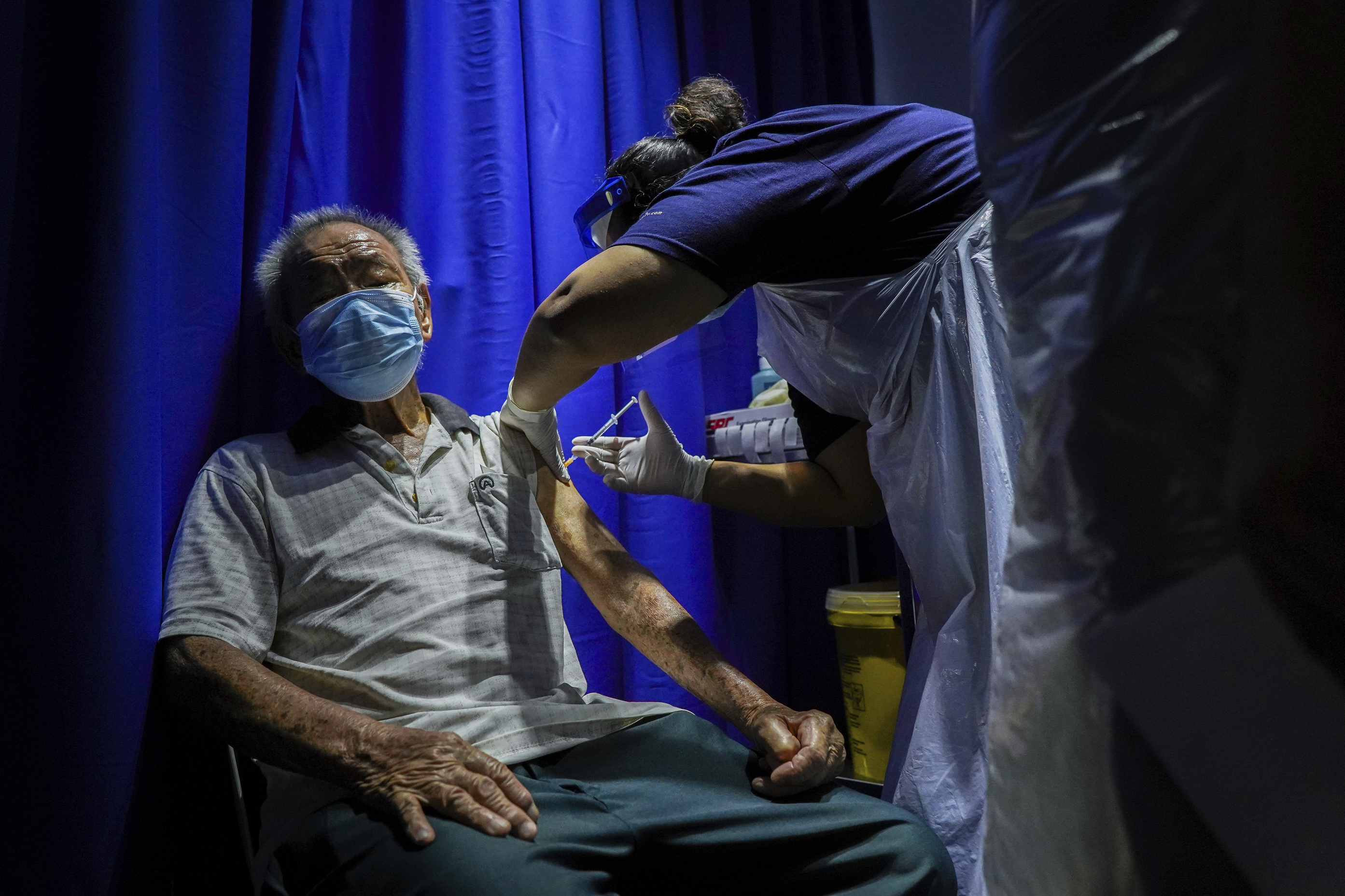 A healthcare worker administers a dose of a COVID-19 vaccine during mobile vaccination drive in Kuala Lumpur. Photo by Mohd Firdaus / AP