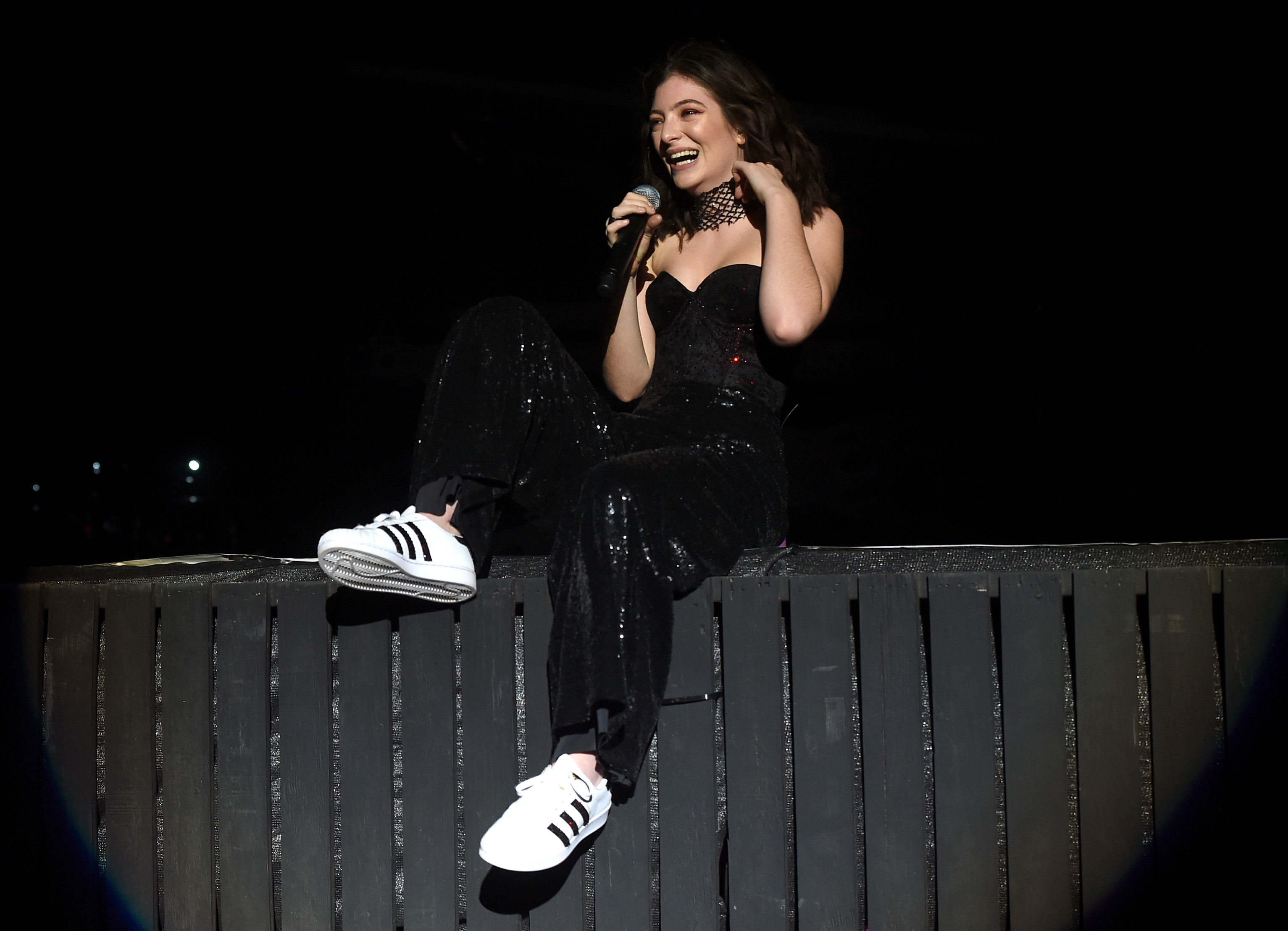 lorde sitting on top of a fence singing at coachella 2017