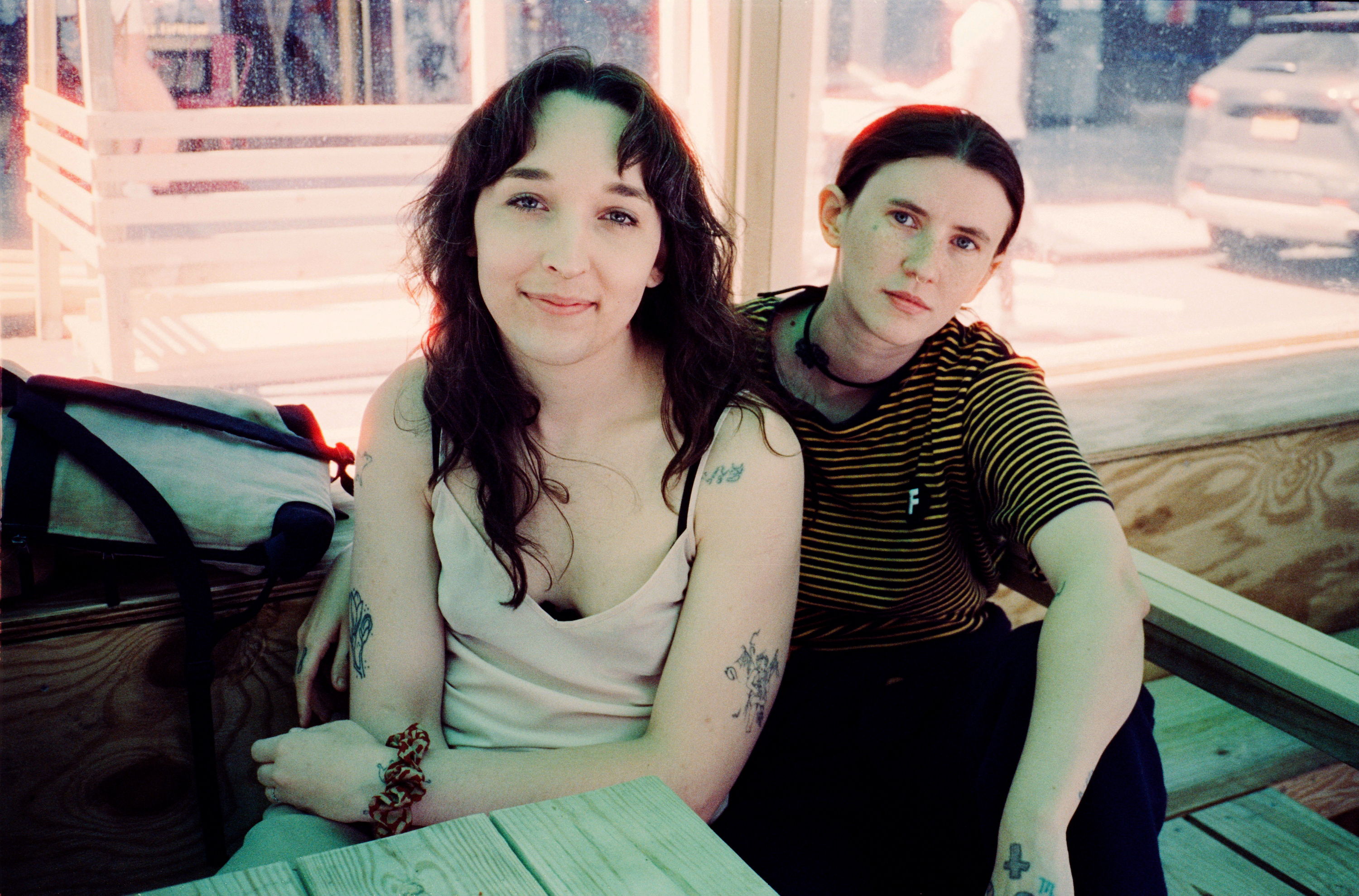 a portrait of magdalena galen and ripley sitting at a wooden table in nyc