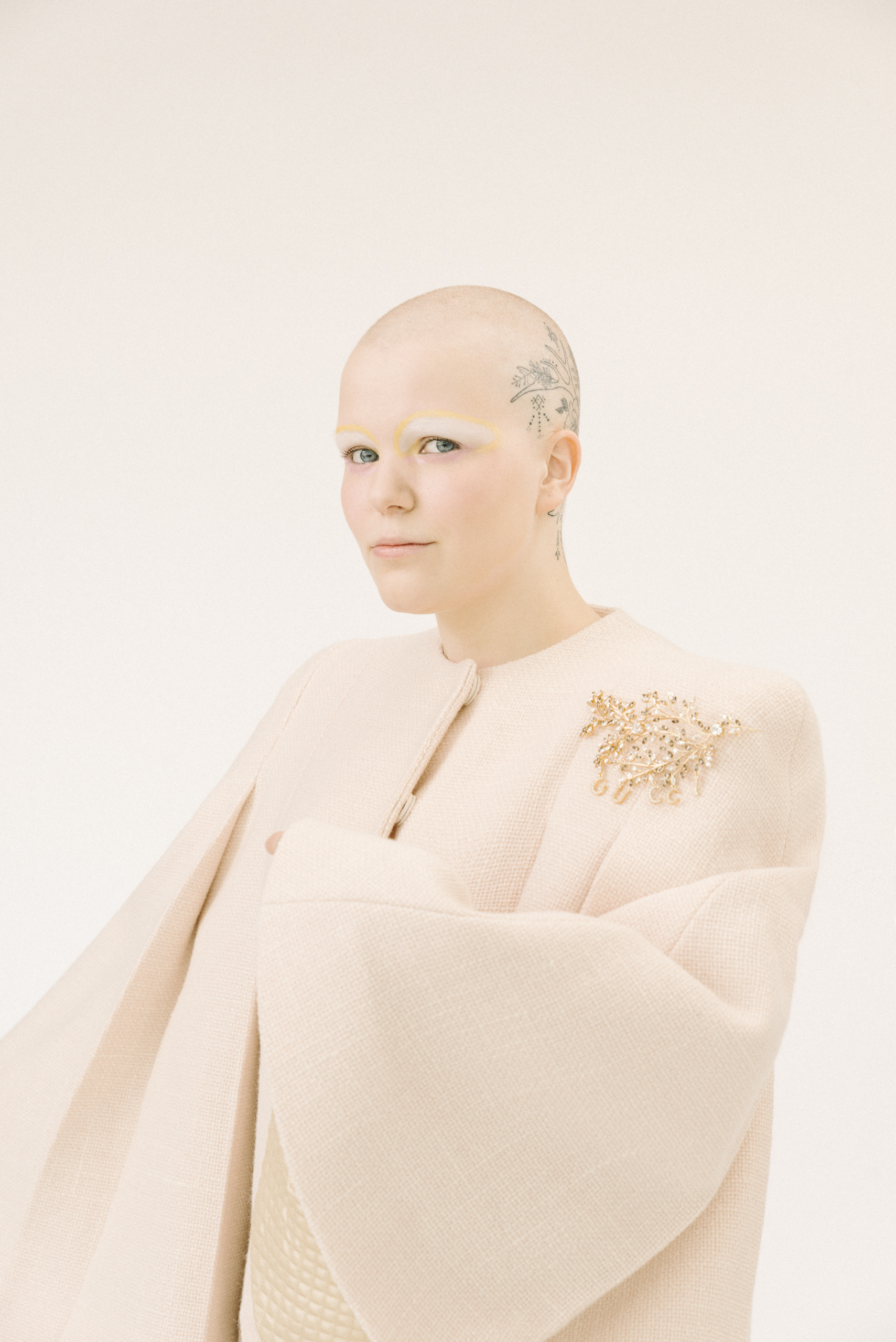 Ophelian con trucco bianco e giallo e mantella rosa cipria