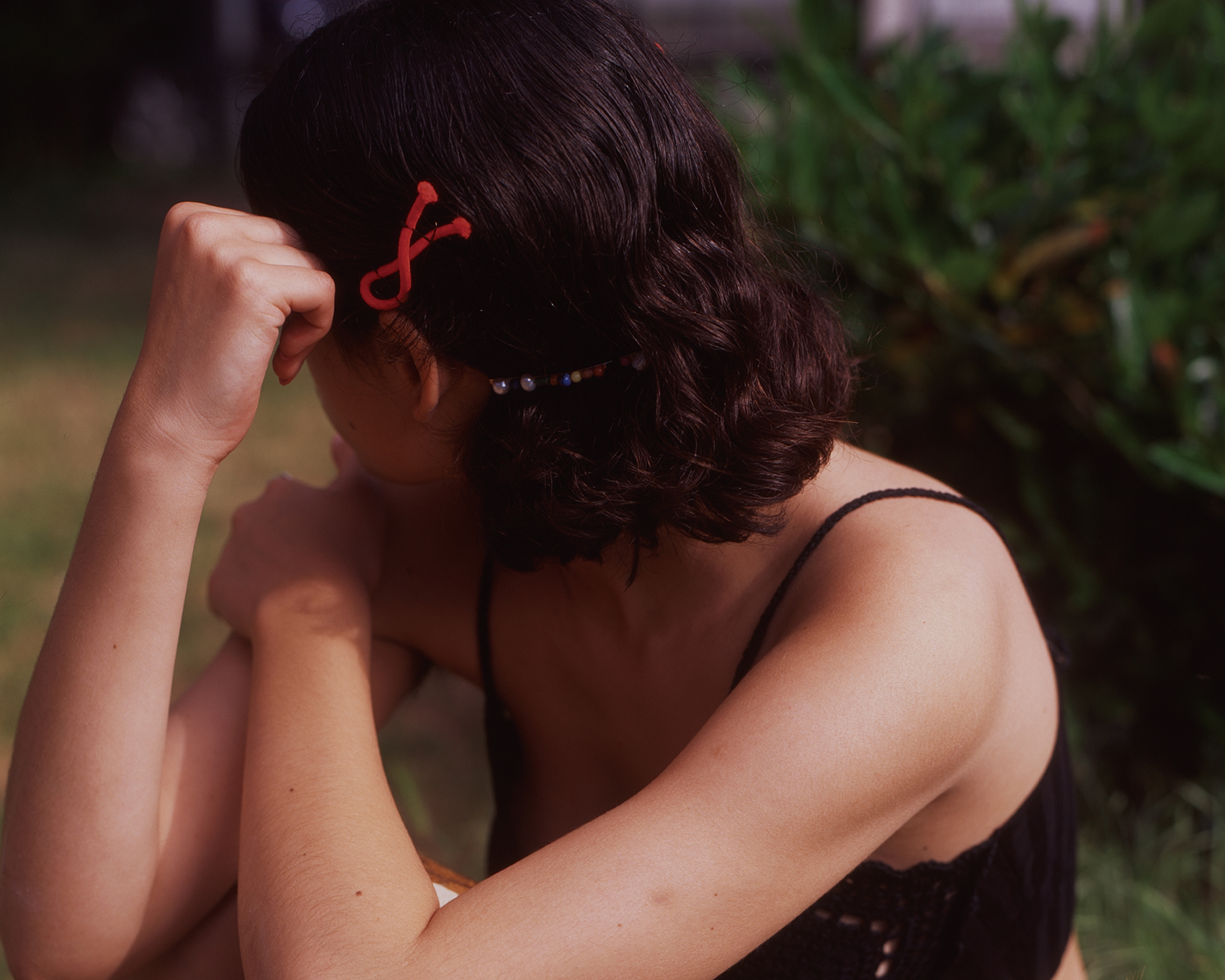 ragazza con fiocco rosso nei capelli in mezzo a un parco