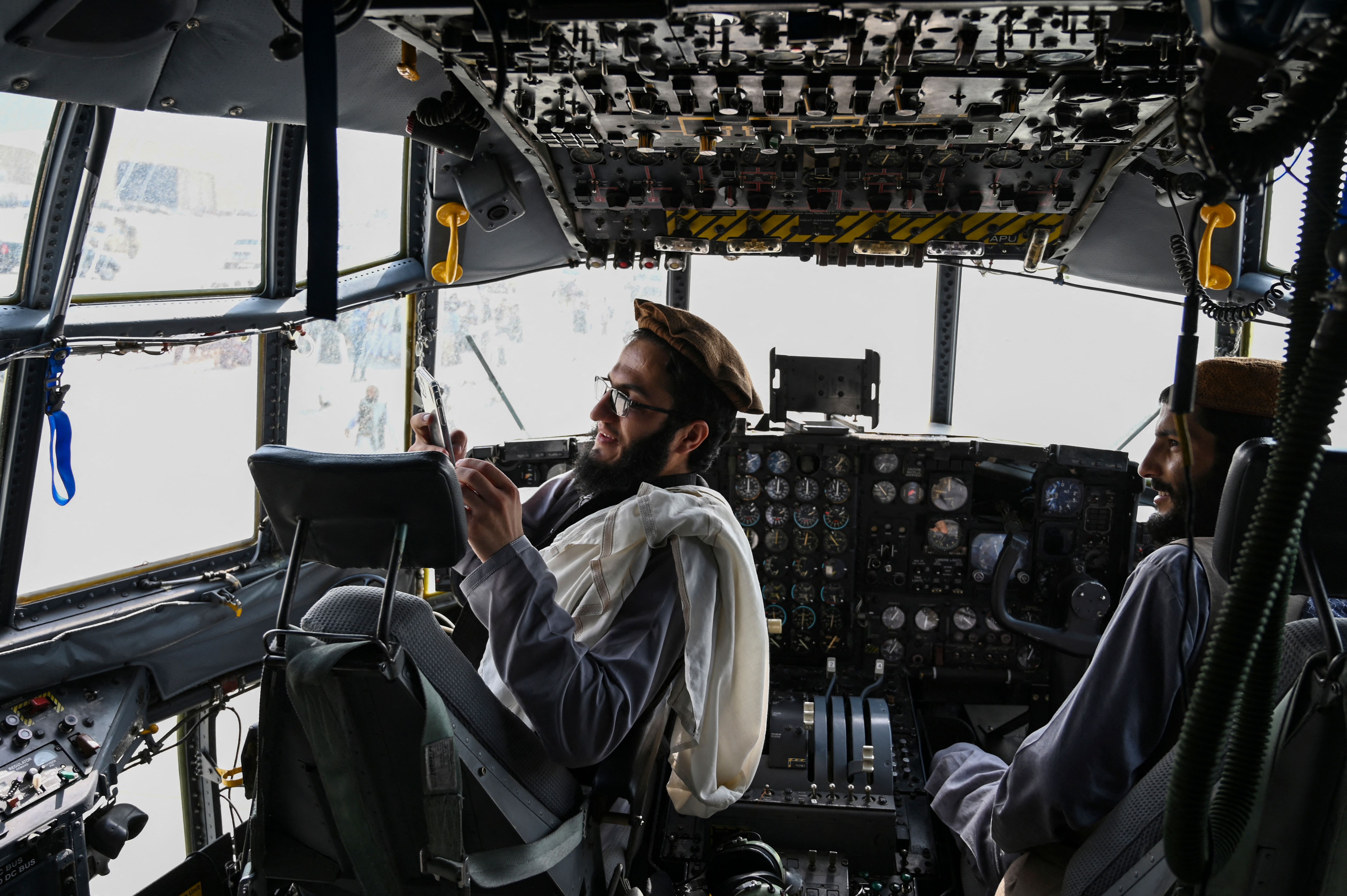 Dua prajurit Taliban duduk di kokpit pesawat Angkatan Udara Afghanistan yang terbengkalai di bandara Kabul akhir Agustus lalu, tak lama setelah pasukan AS pulang ke negara mereka. Foto: Wakil Kohsar/AFP via Getty Images