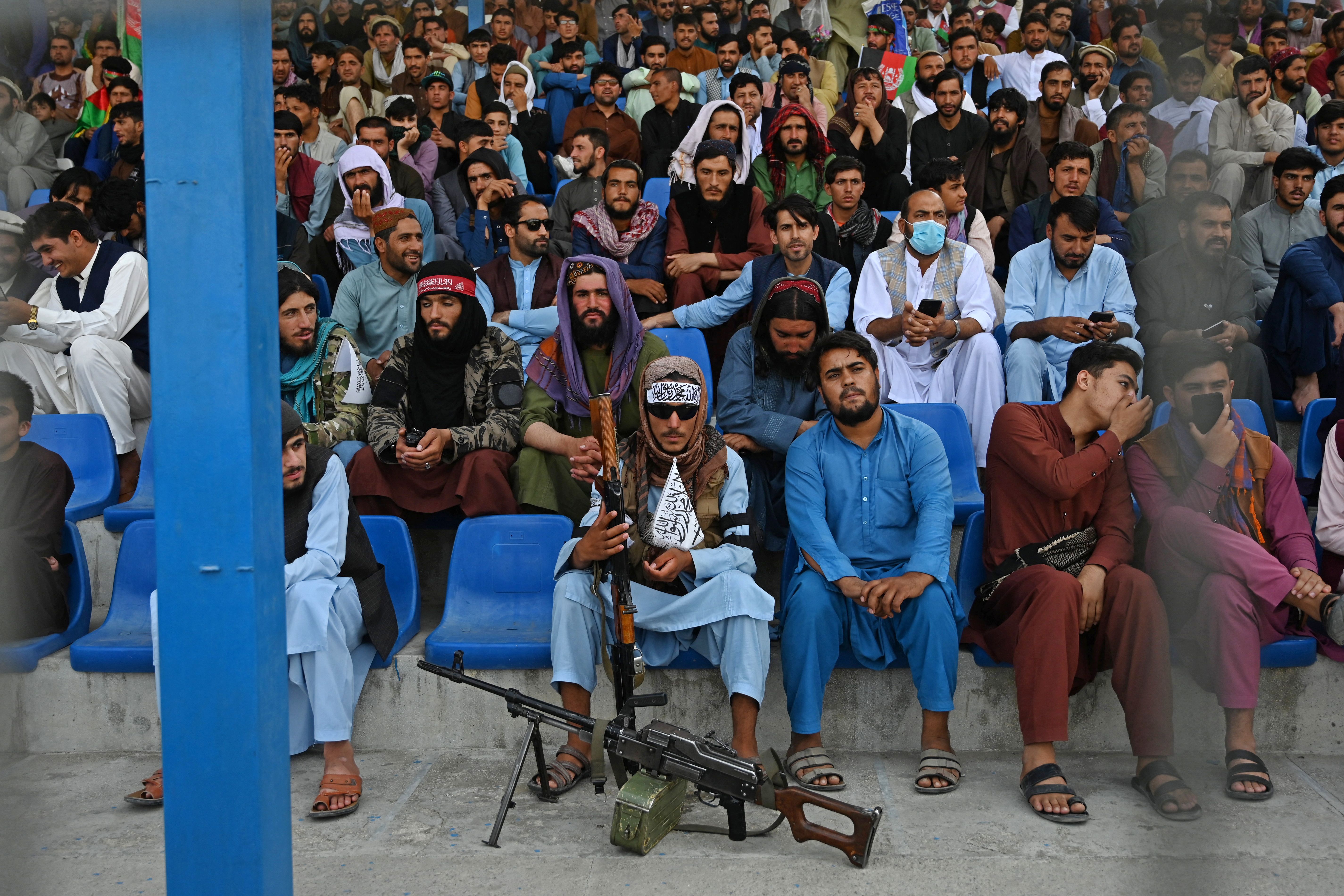 Prajurit Taliban duduk di antara penonton yang menyaksikan pertandingan kriket Twenty20 di Kabul pada awal September. Foto: Aamir Qureshi/AFP via Getty Images