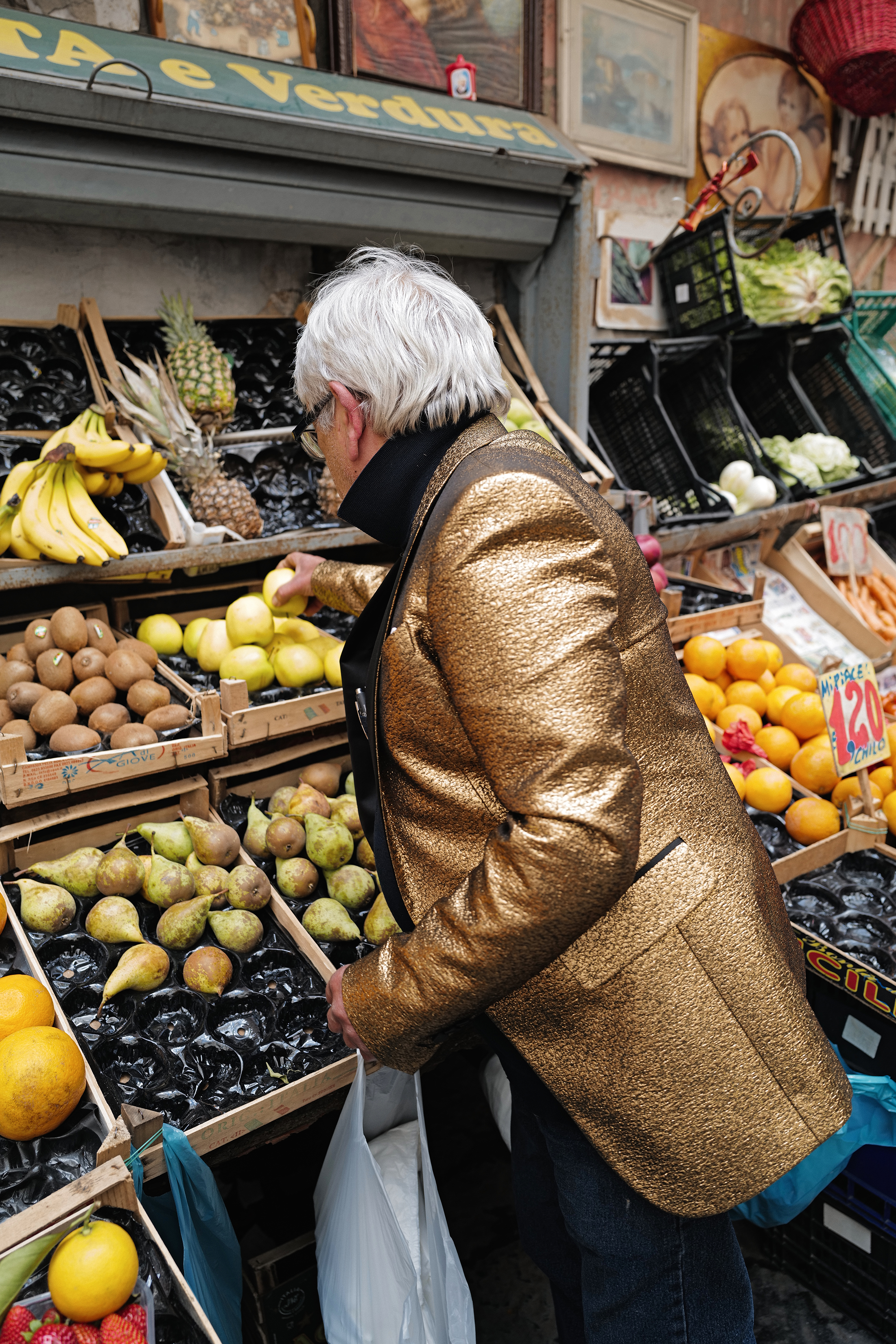 signore in abito dorato che compra frutta