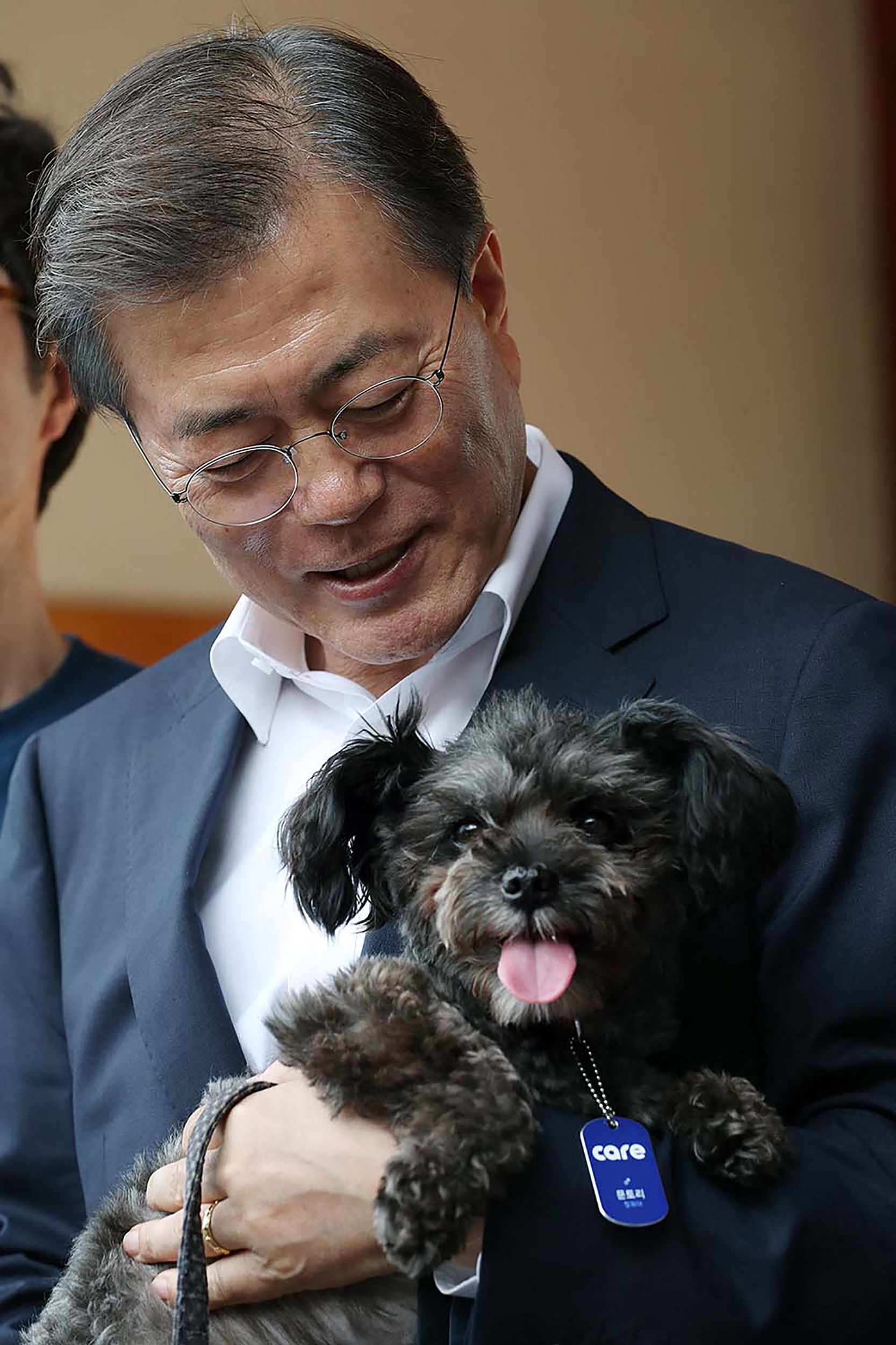 Presiden Korea Selatan Moon Jae-in menggendong anjing mutt hitam yang dilaporkan akan dibunuh sebelum akhirnya diselamatkan dua tahun lalu. Foto: Handout / The Blue House / AFP