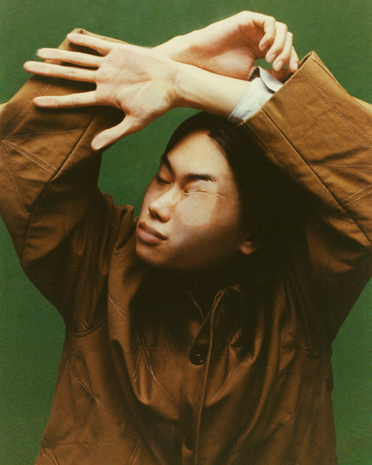 a photograph of a person in a brown leather jacket with their face pressed up against glass, distorting it