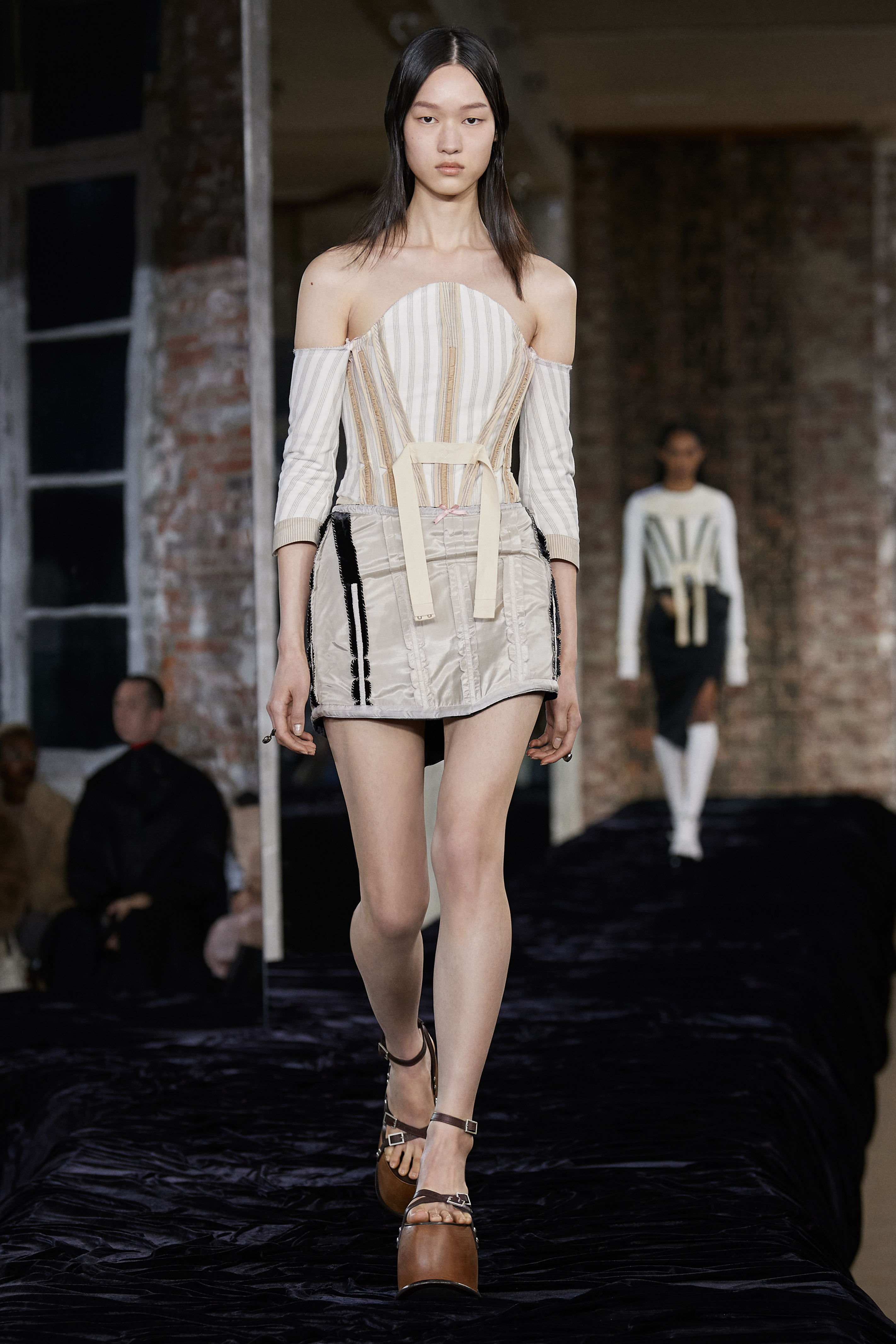 Acne Studios SS22: a model wears a creme-coloured boned bodice and matching mini skirt with chunky wooden heels