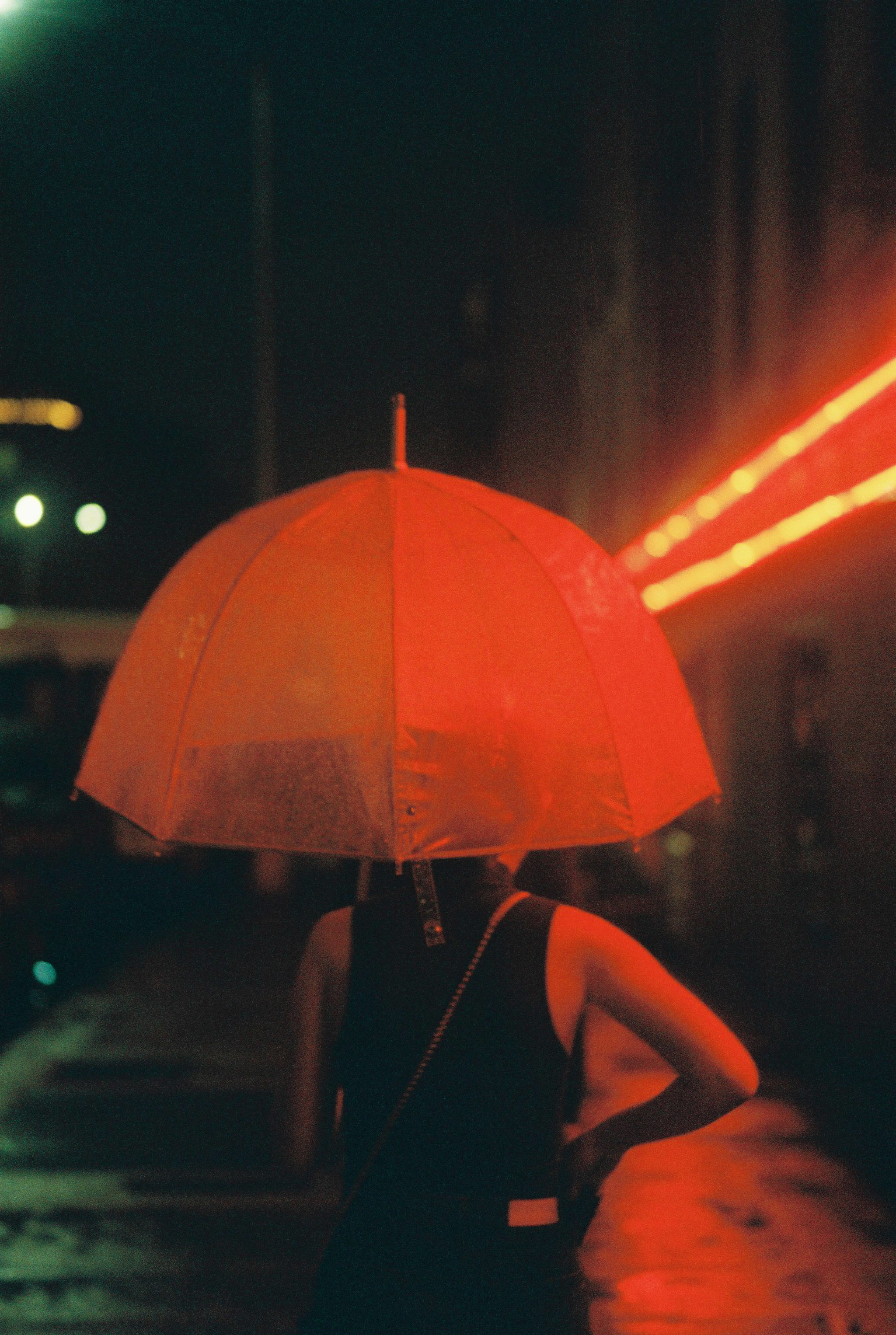 an umbrella lit up by a red neon light