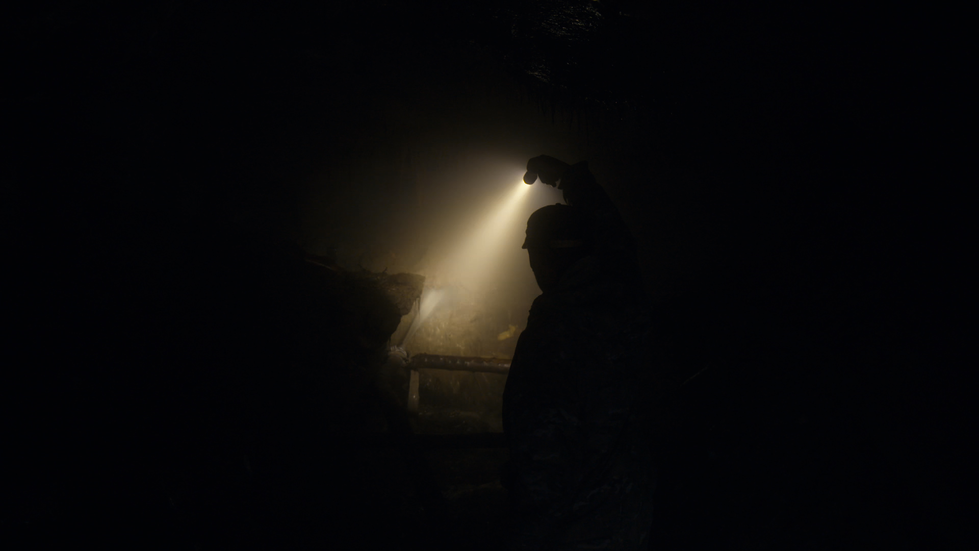 Lelaki menyalakan senter di dalam terowongan