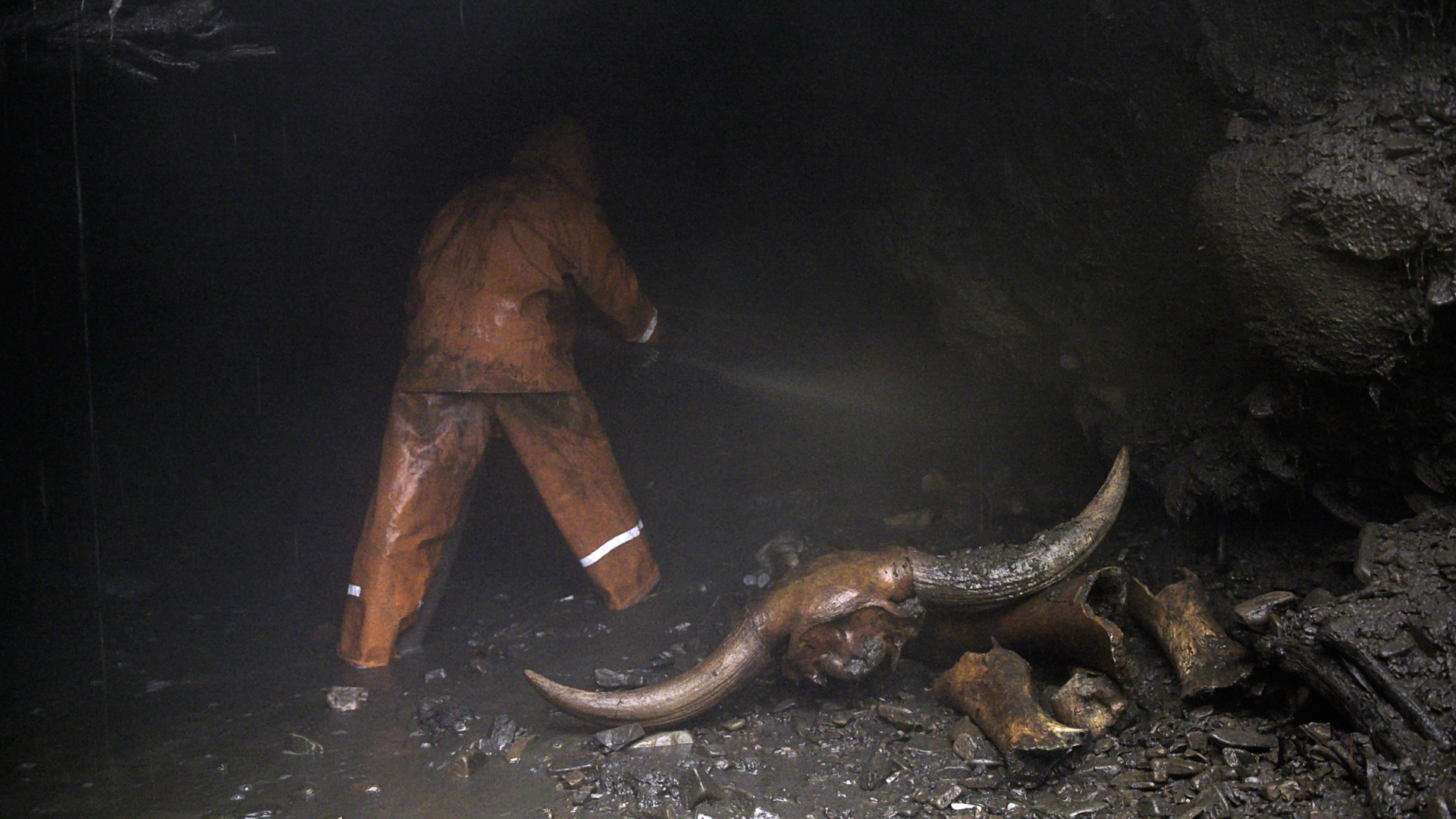 Pemburu menggali terowongan. Di sebelahnya ada kepala bison purba.