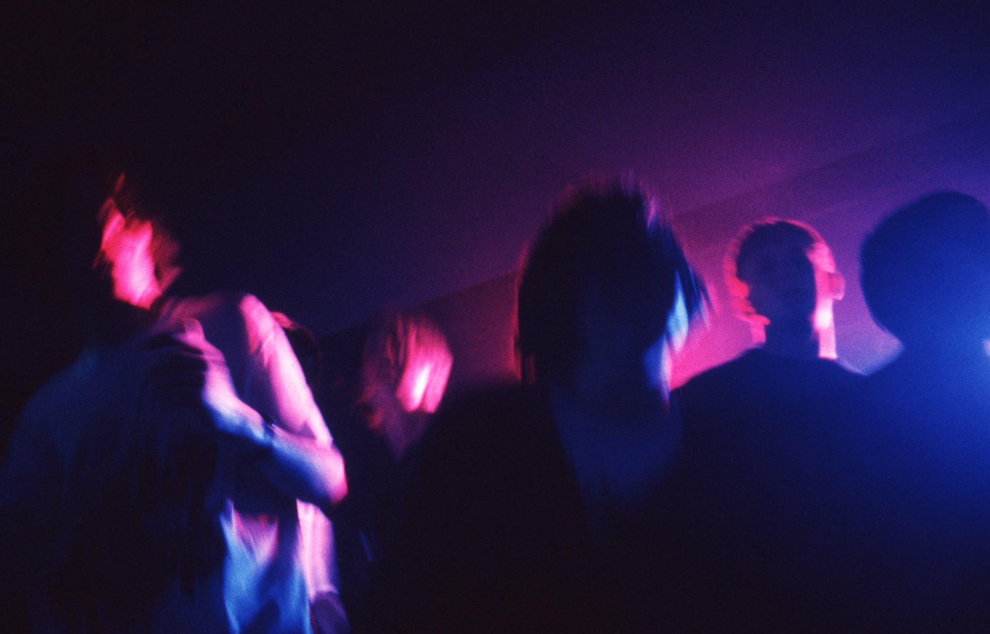 people dancing bathed in purple light