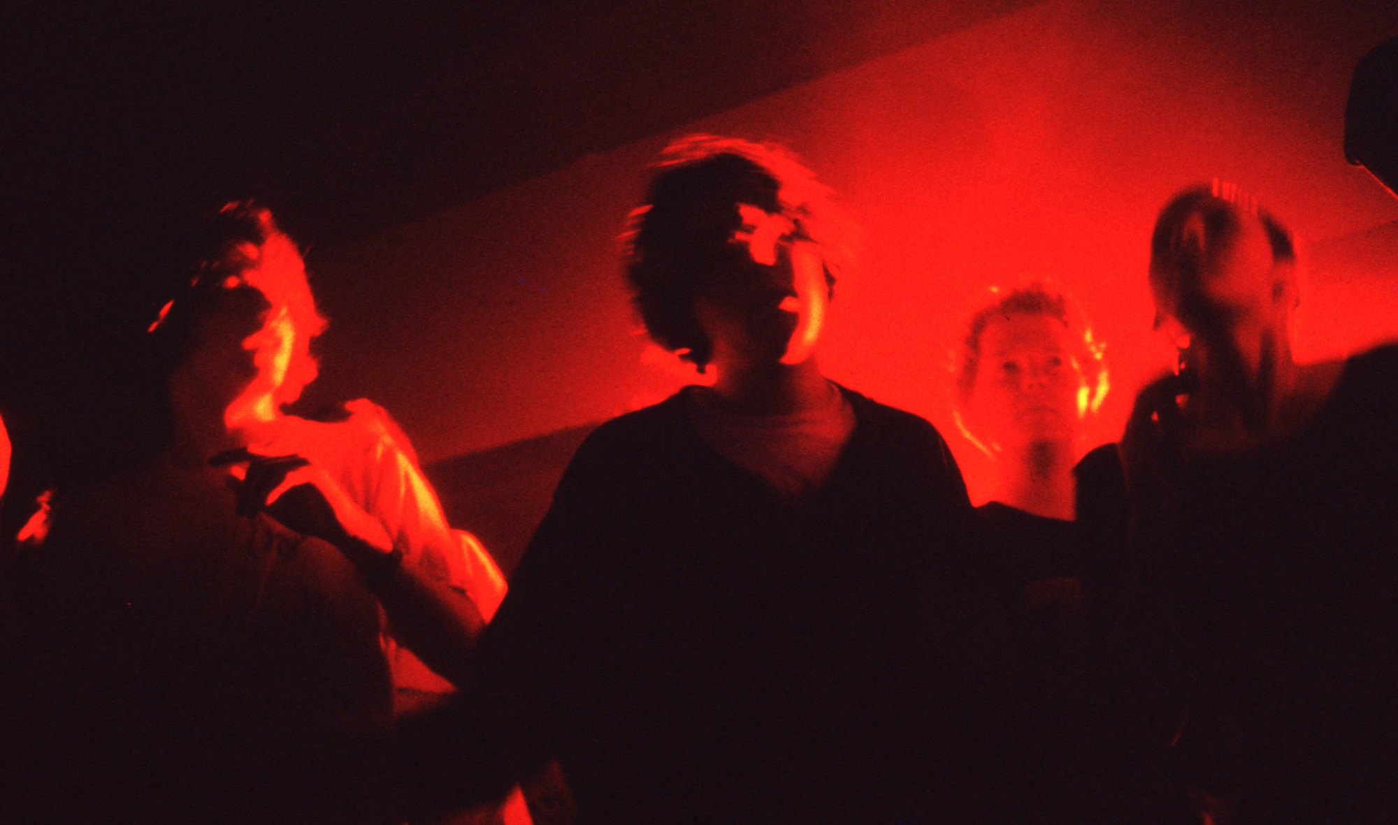 people dancing bathed in red light