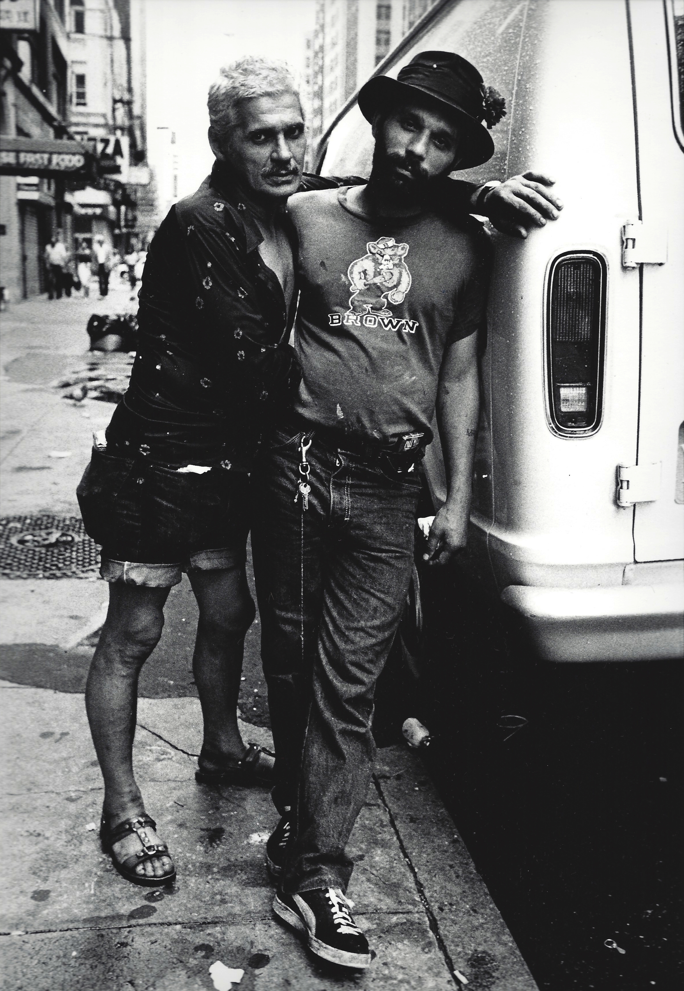 two men leaning on one another on the street in new york