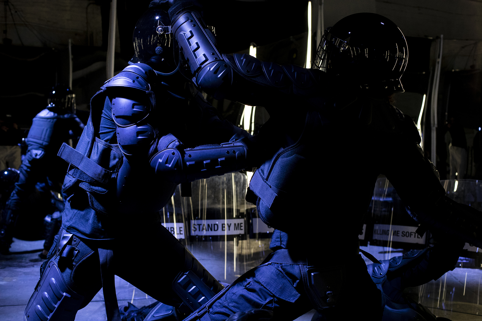 two people in riot gear simulate fighting